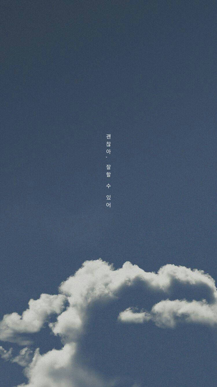 korean 桌布 壁紙 — 寧靜的藍天，帶有柔軟的白雲，上方居中垂直的韓文文字。