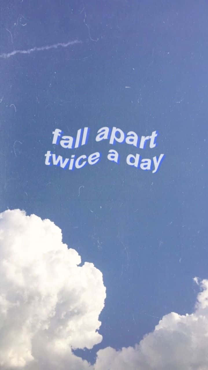 Blue Sky Aesthetic 桌布 壁紙 — 寧靜的藍天，蓬鬆的白雲，以及「fall apart twice a day」這句話在柔和焦點中漂浮。