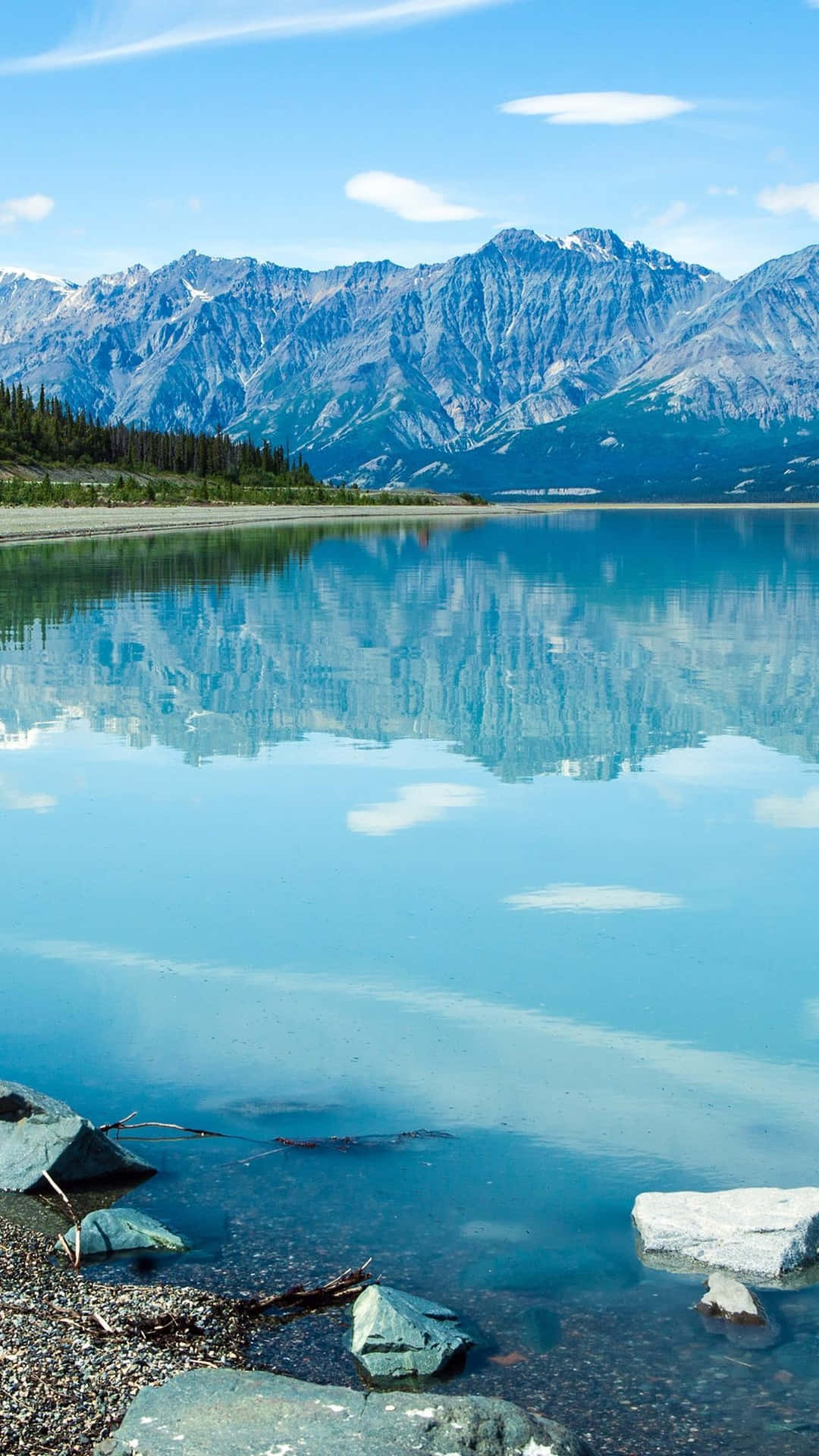 桌布 壁紙 — 寧靜的高山湖泊映照著白雪覆蓋的山峰，天空湛藍，雲朵點綴。