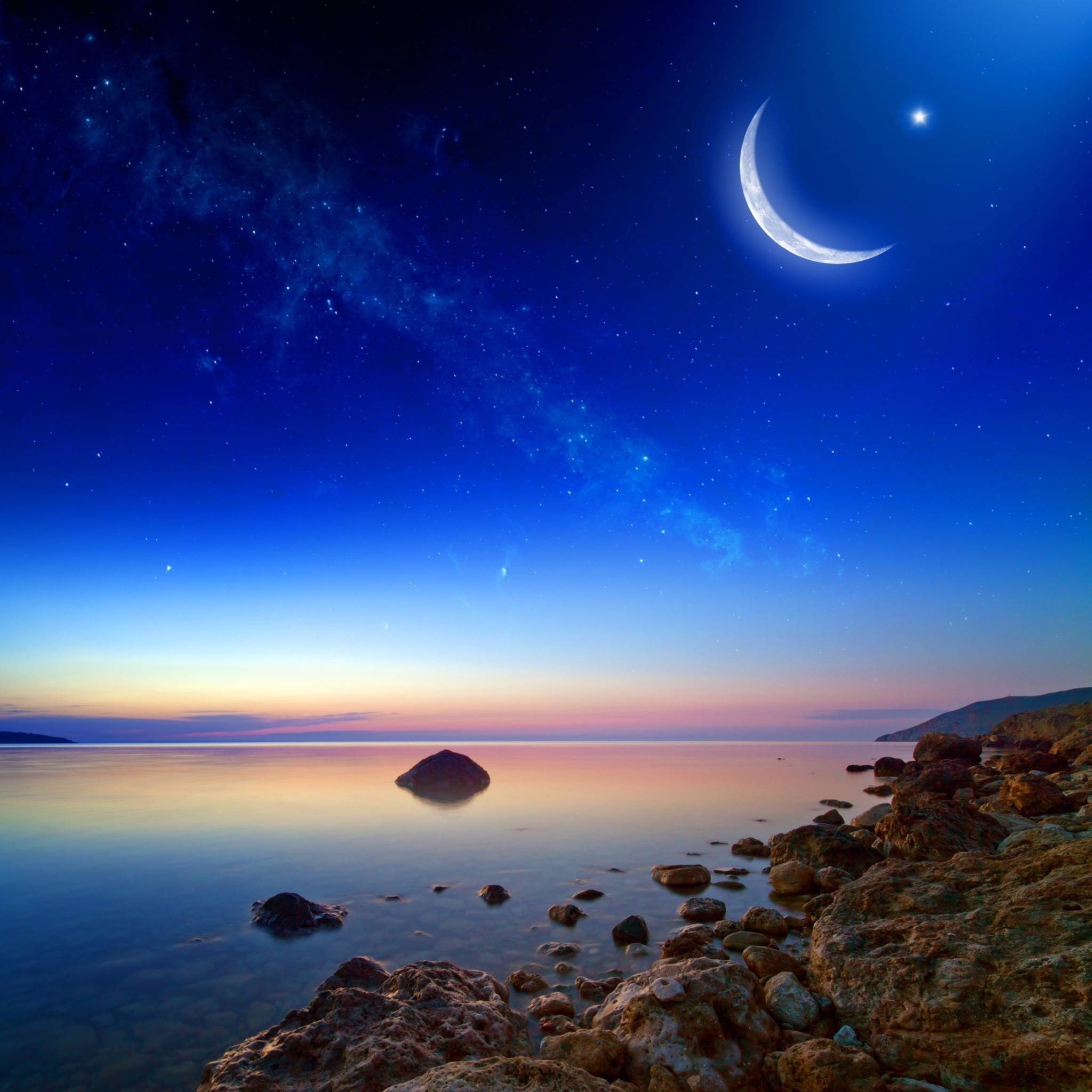 Calming 桌布 壁紙 — 寧靜的黃昏海景，新月和星星在平靜的水面和岩石海岸上方。