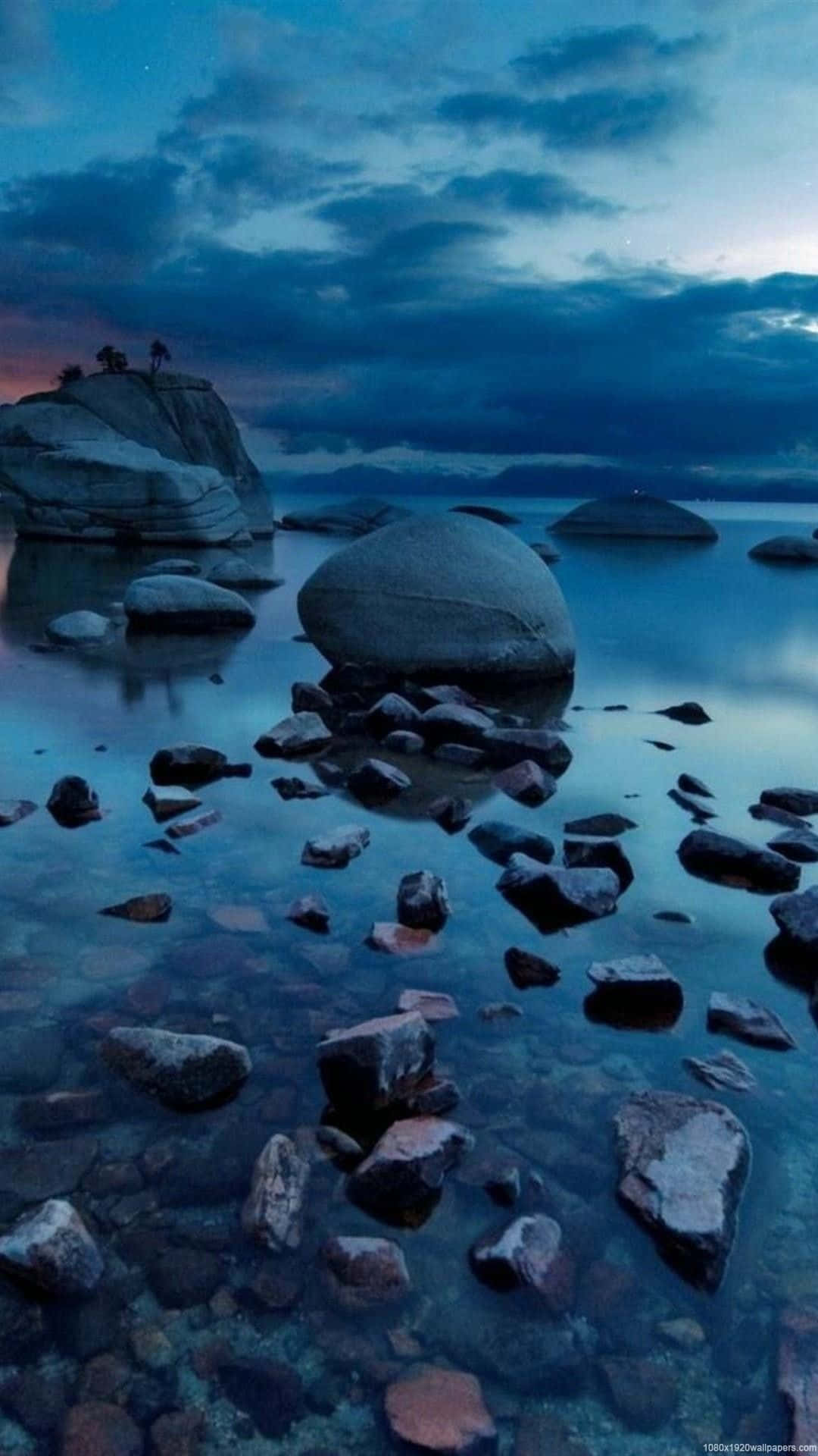 自然 桌布 壁紙 — 寧靜的黃昏湖景，光滑的巨石和清澈的湖水映照著星空和遠方的懸崖。