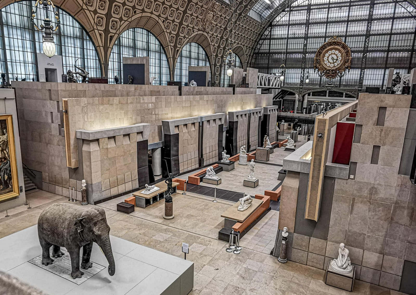 Museum 桌布 壁紙 — 寬敞的博物館大廳，拱形玻璃天花板下擺放著石像和一尊大型大象雕塑。