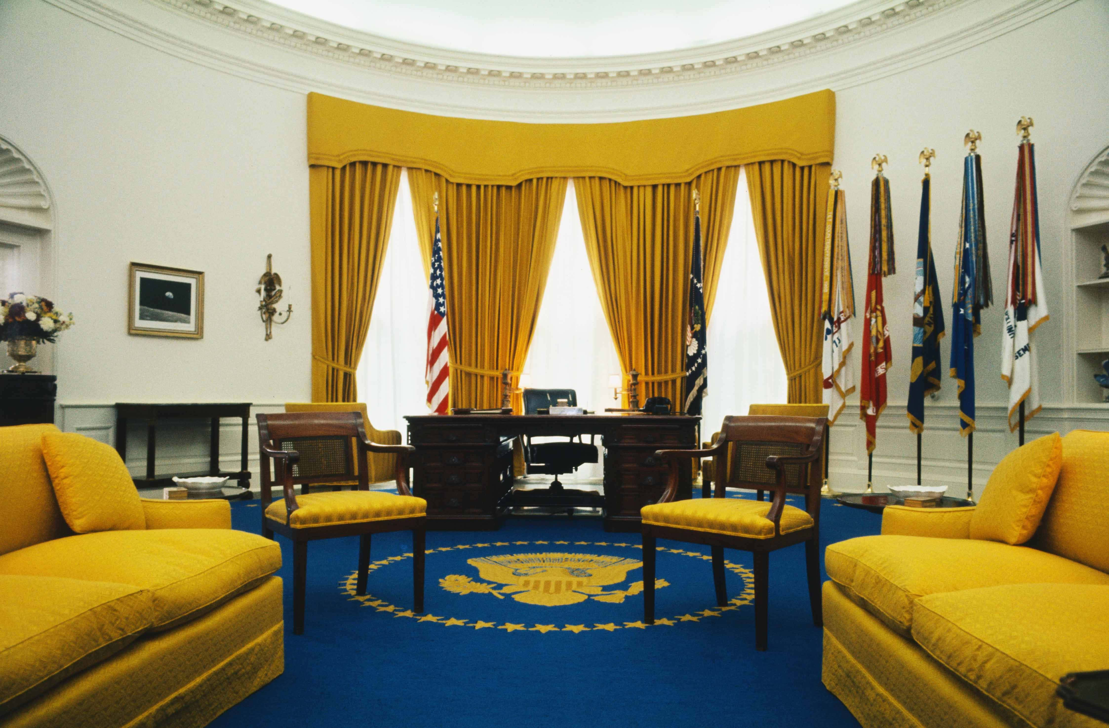 white house 桌布 壁紙 — 寬敞的橢圓形辦公室，金色窗簾和家具圍繞著總統辦公桌，在明亮的日光下。