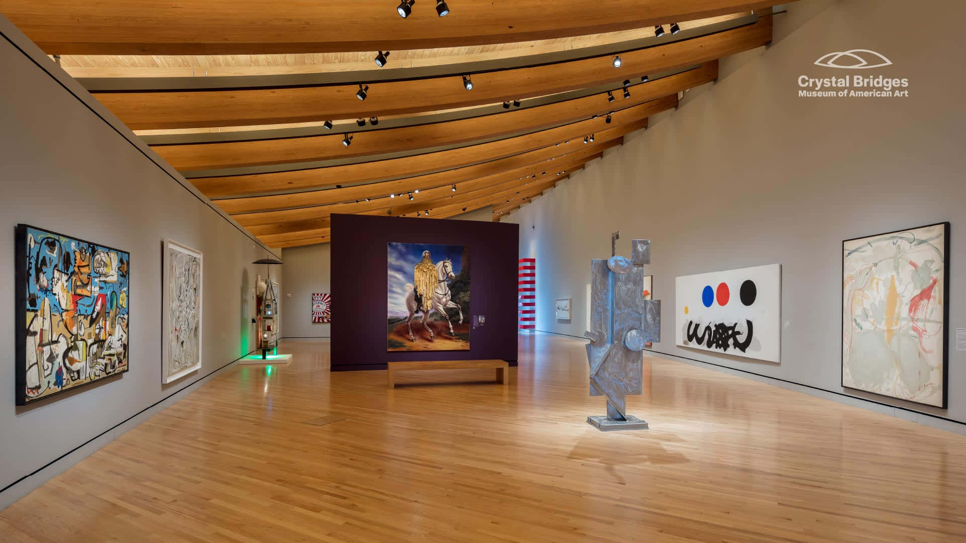 Museum 桌布 壁紙 — 寬敞的藝術畫廊，鋪有木地板和橫樑，在聚光燈下展示充滿活力的繪畫和雕塑。