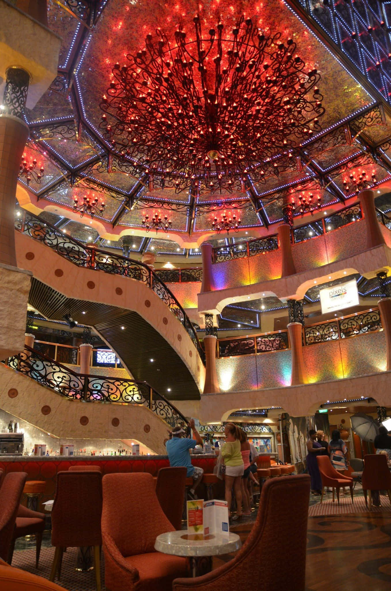 Carnival Vista 桌布 壁紙 — 寬敞賭場大廳，巨型紅色吊燈照亮多層陽台及桌旁賓客。