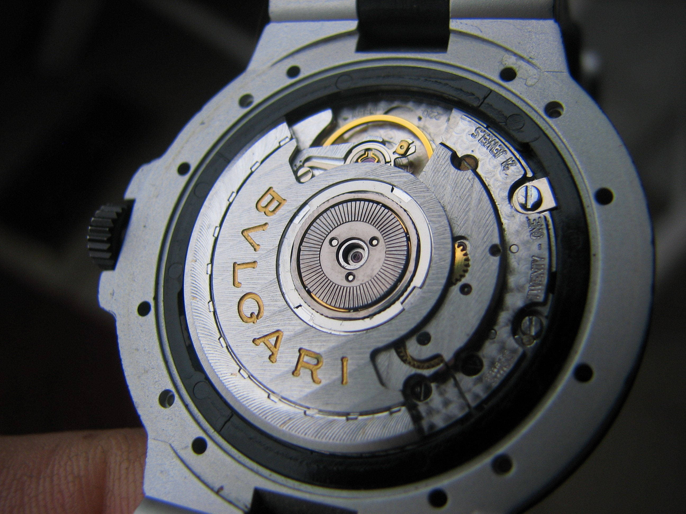 Bvlgari 桌布 壁紙 — 寶格麗手錶背面的特寫，展現出複雜的銀色和金色機械齒輪及雕刻。