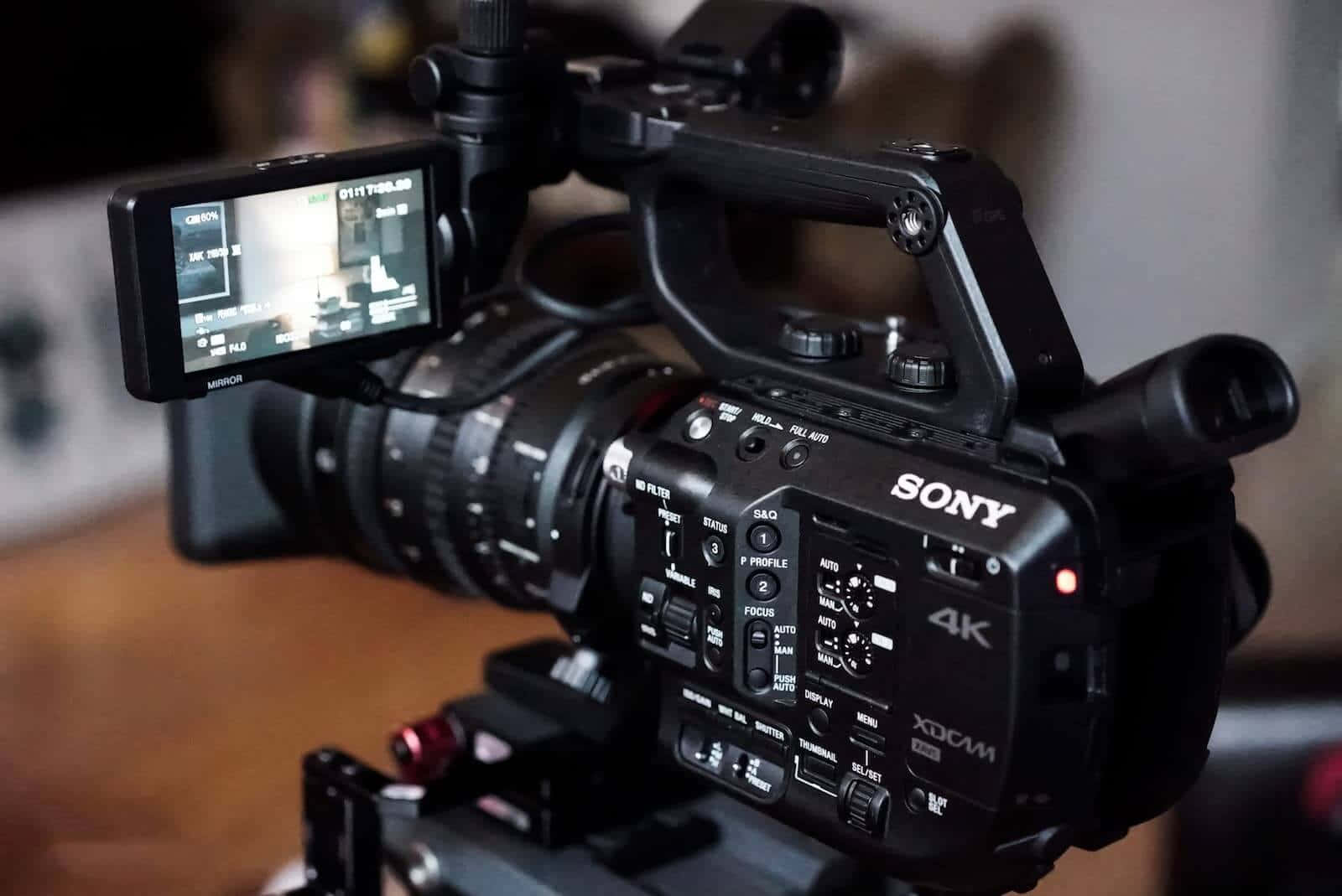 影片 桌布 壁紙 — 專業Sony 4K攝錄影機，配備鏡頭和顯示器安裝在支架上，準備拍攝。