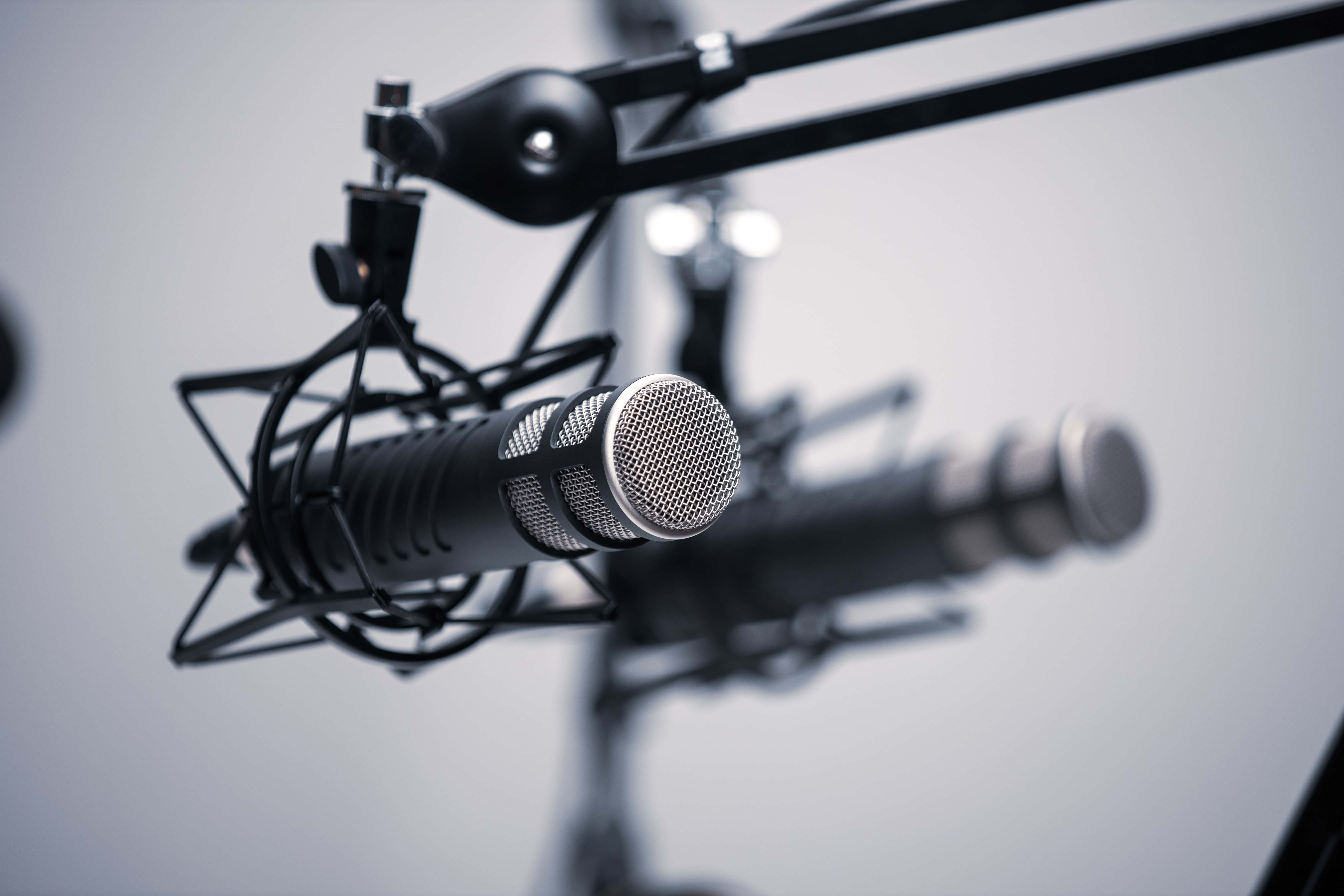 Microphones 桌布 壁紙 — 專業錄音室麥克風安裝在吊臂上的特寫，背景模糊。