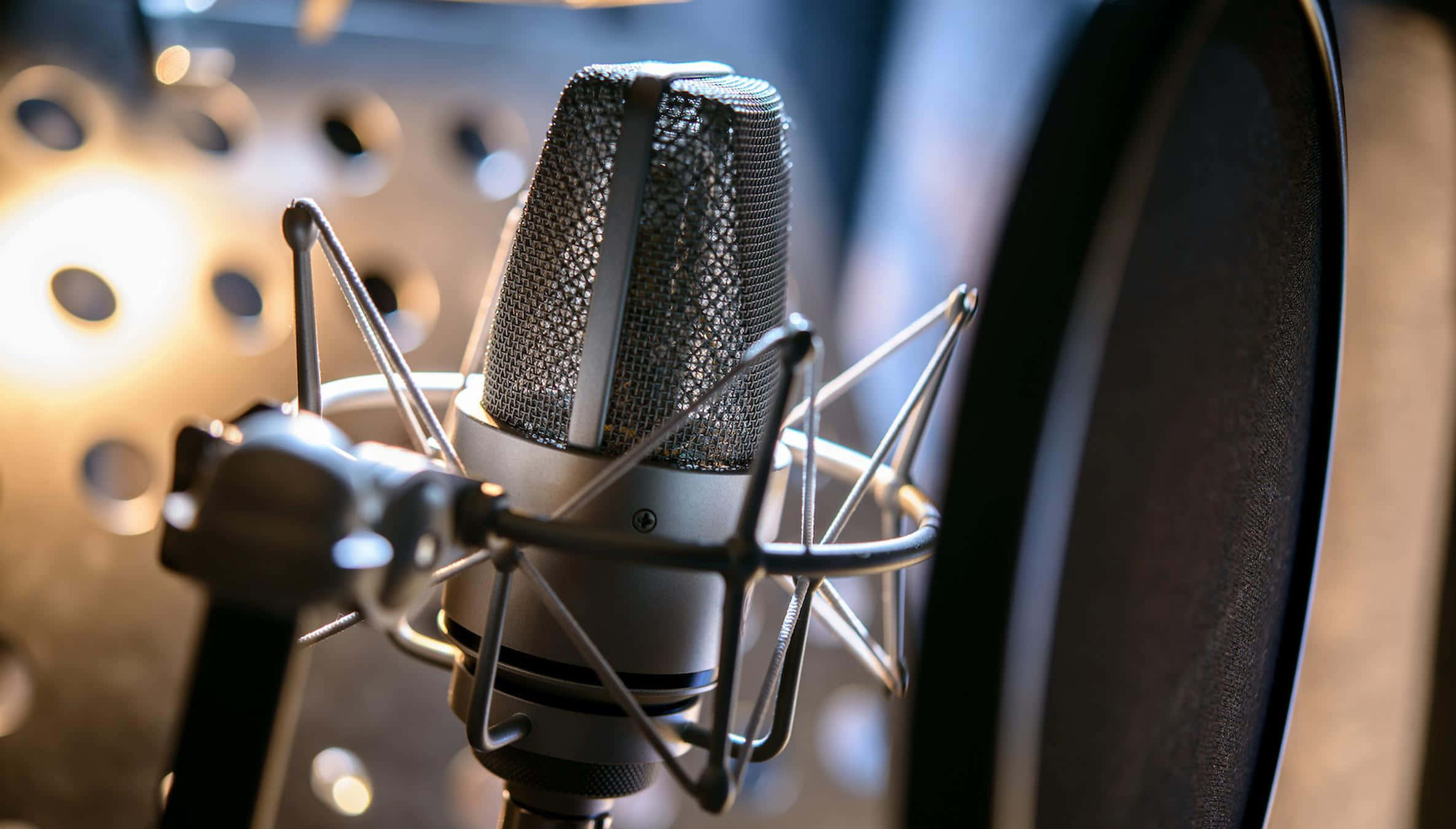 recording 桌布 壁紙 — 專業錄音室麥克風的微距特寫，配有防噴罩和防震架，背景柔和模糊。
