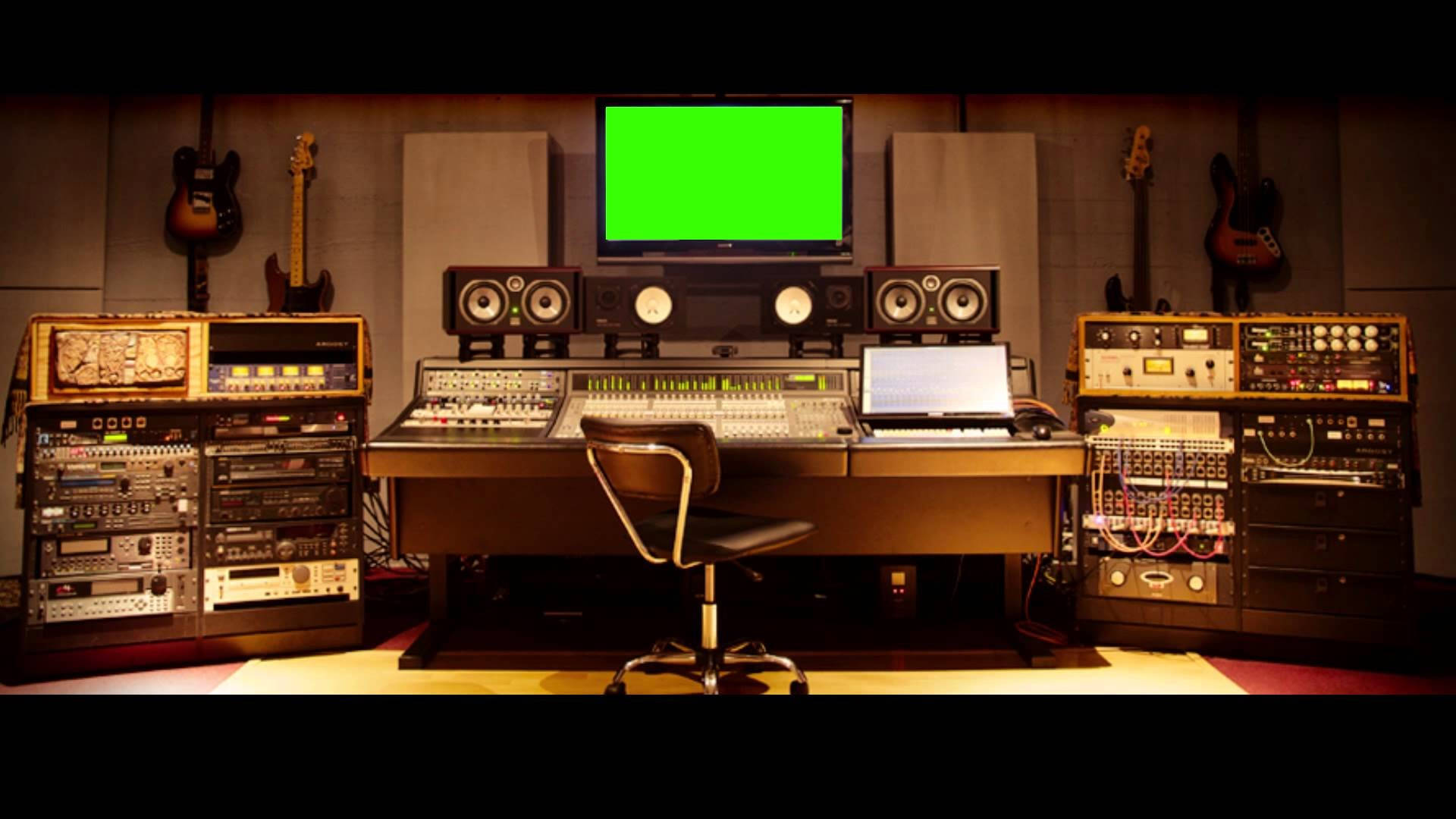專業音樂工作室，配備復古音響設備和掛在隔音牆上的吉他。