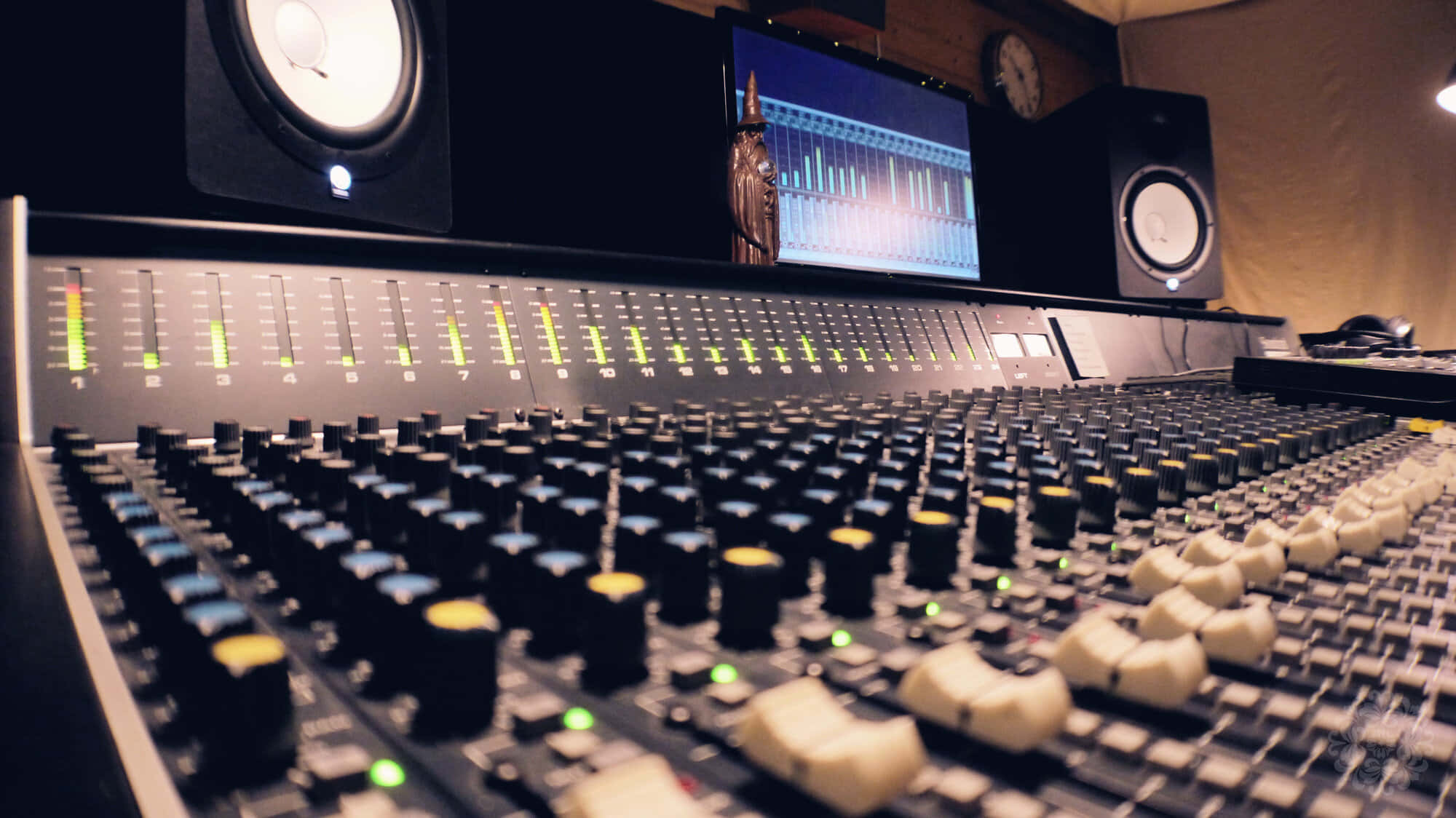 Studio 桌布 壁紙 — 專業音頻混音控制台的近距離特寫，在昏暗的錄音室中帶有發光的推子和揚聲器。