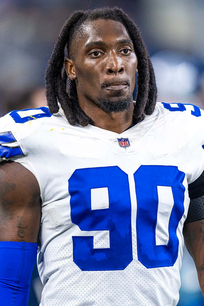 NFL 桌布 壁紙 — 專注的NFL美式足球運動員特寫，留著辮子頭，身穿白色和藍色球衣，號碼90。