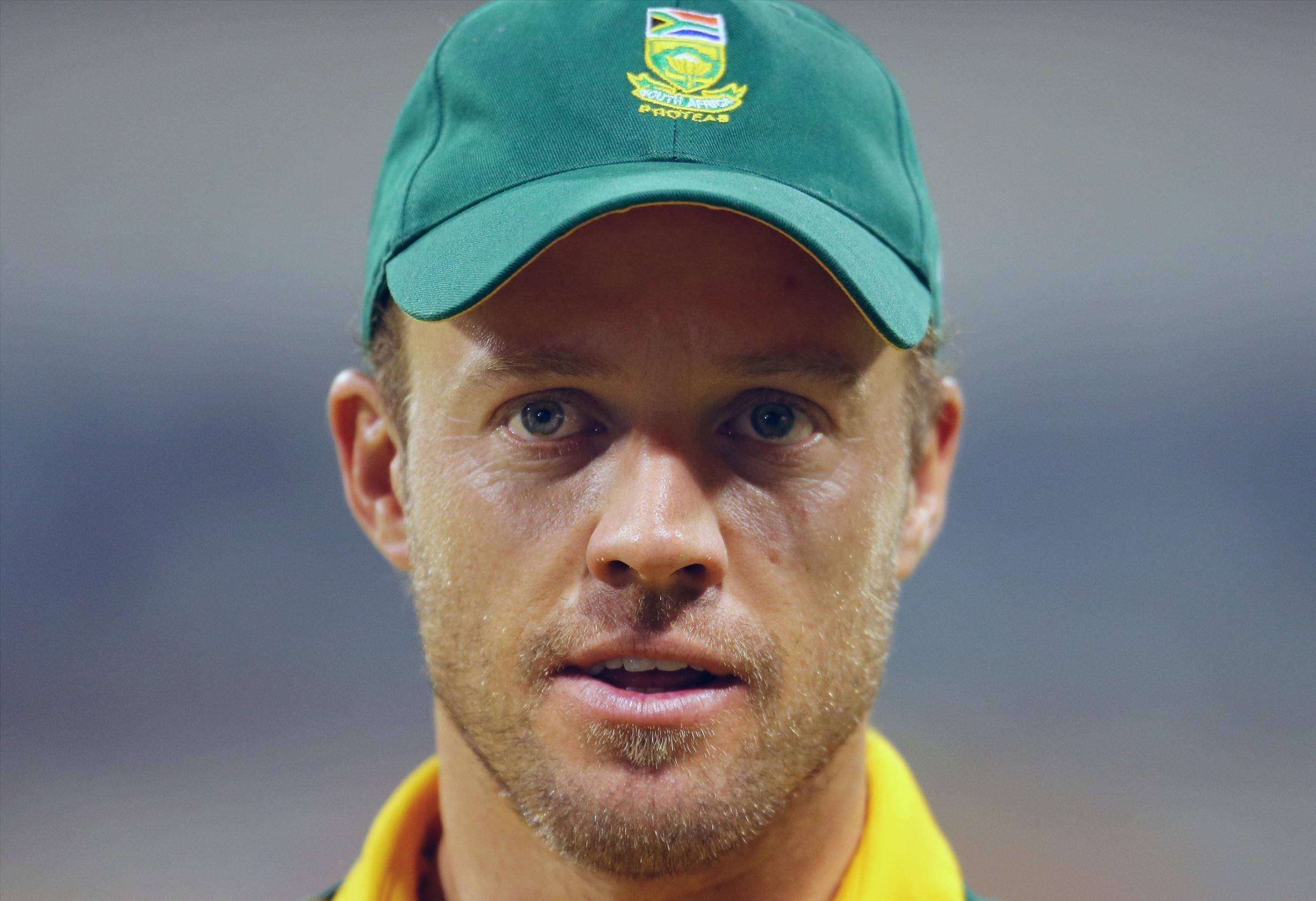 Ab De Villiers 桌布 壁紙 — 專注的南非 Proteas 板球運動員特寫，戴綠色帽子和黃色衣領。