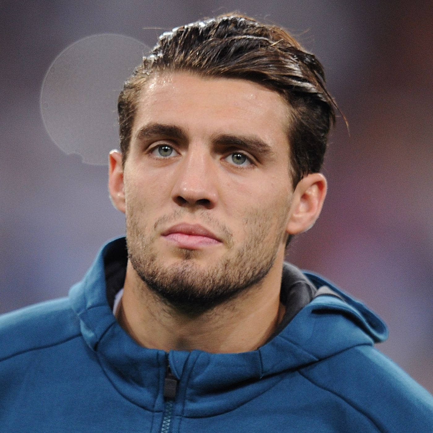 Football Players 桌布 壁紙 — 專注的年輕男子藍眼睛濕頭髮穿著藍色連帽衫的特寫。