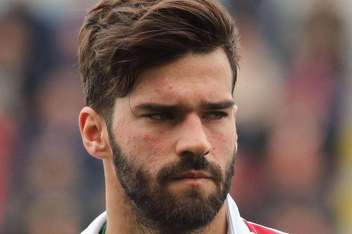Alisson Becker 桌布 壁紙 — 專注的鬍鬚男近距離特寫，眼神強烈，身穿紅白運動球衣。