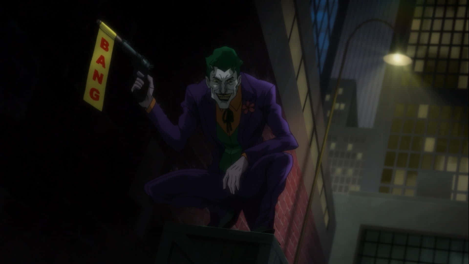 Batman Hush 桌布 壁紙 — 小丑在夜晚蹲在屋頂上，在黑暗的城市環境中手持一把帶有「BANG」標誌的槍。