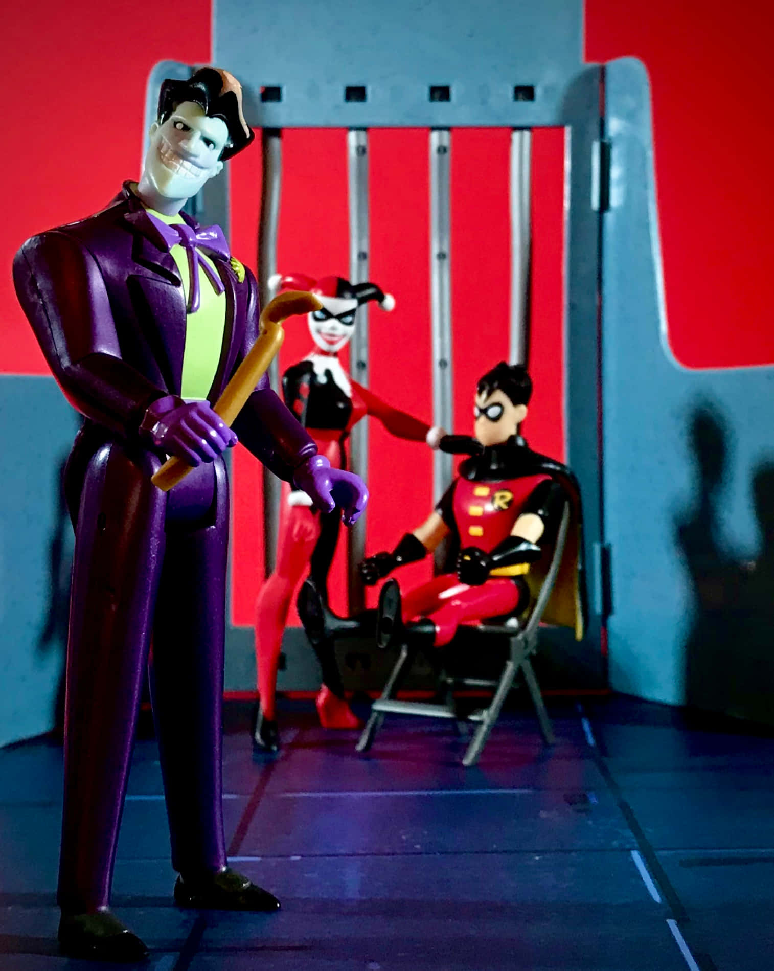 Batman Beyond Return Of The Joker 桌布 壁紙 — 小丑在監獄牢房場景中，威脅性地將警棍舉在羅賓上方，而哈莉·奎茵站在他身後。