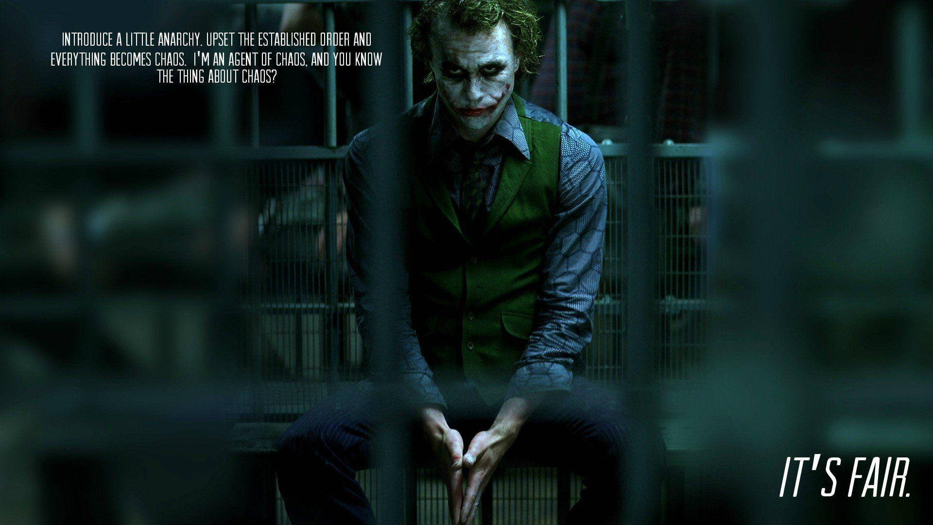 Heath Ledger 桌布 壁紙 — 小丑坐在光線昏暗的牢房鐵欄後，身穿綠色背心，白色臉部化妝，紅唇。