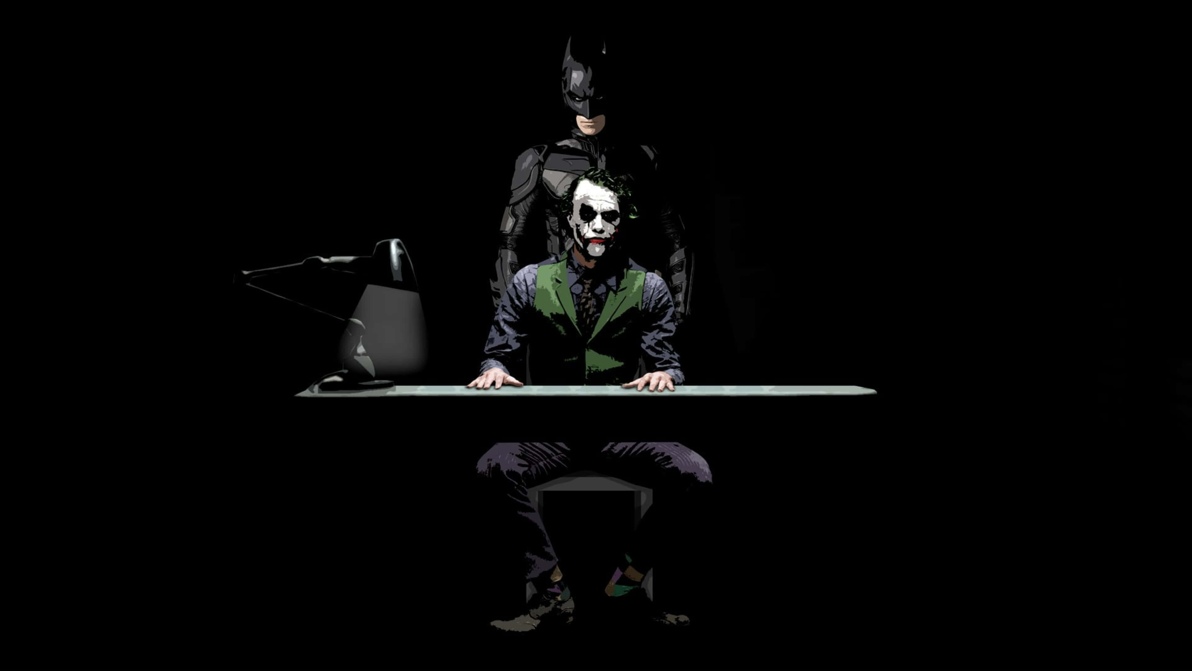 Dark Knight Joker In 4K Ultra HD 桌布 壁紙 — 小丑坐在書桌前，蝙蝠俠在他身後若隱若現，構成黑暗而戲劇性的漫畫場景。