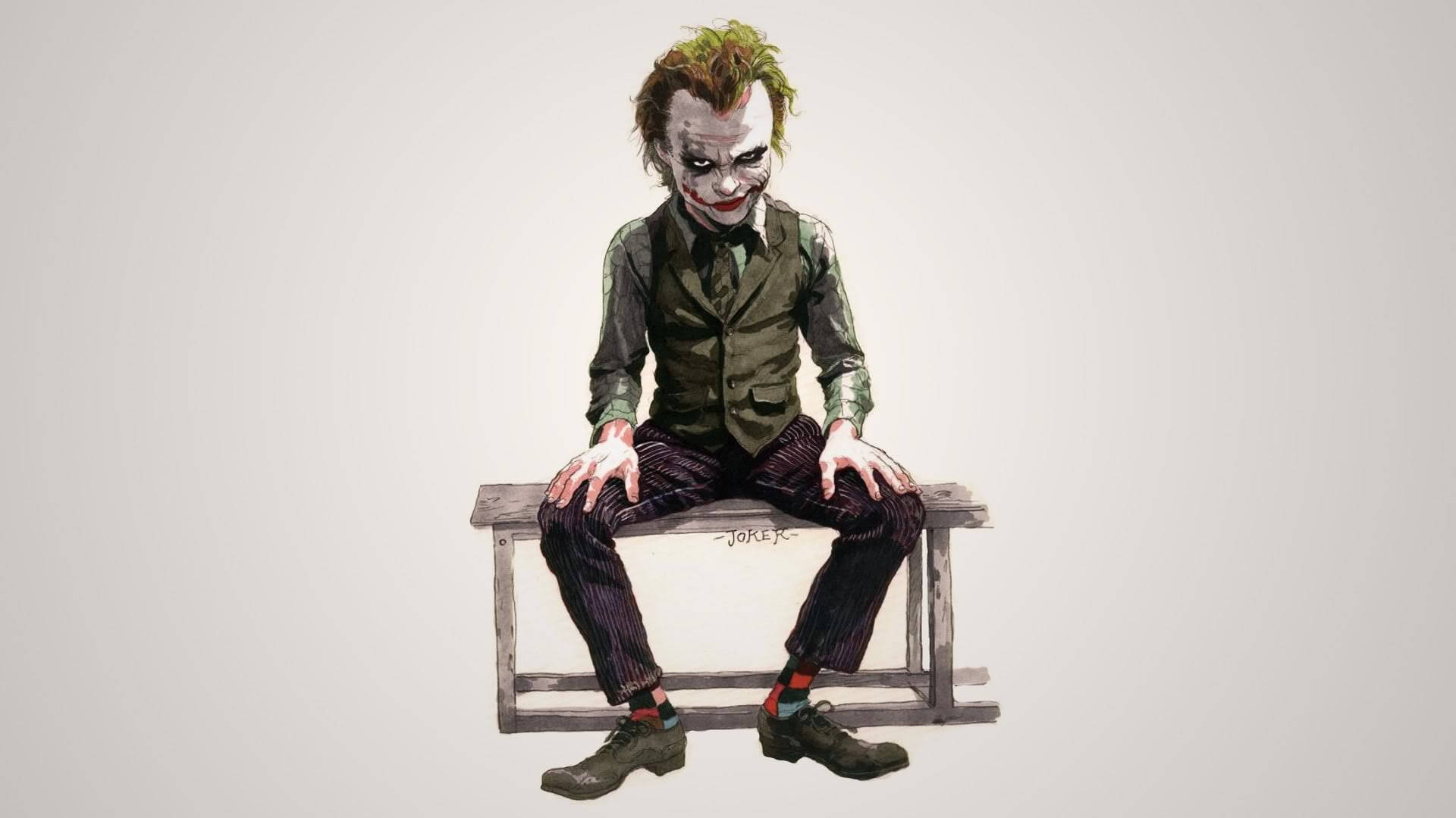 Heath Ledger Joker 桌布 壁紙 — 小丑坐在木長椅上，身穿綠色西裝和條紋褲，露出邪惡的笑容，背景為純色。