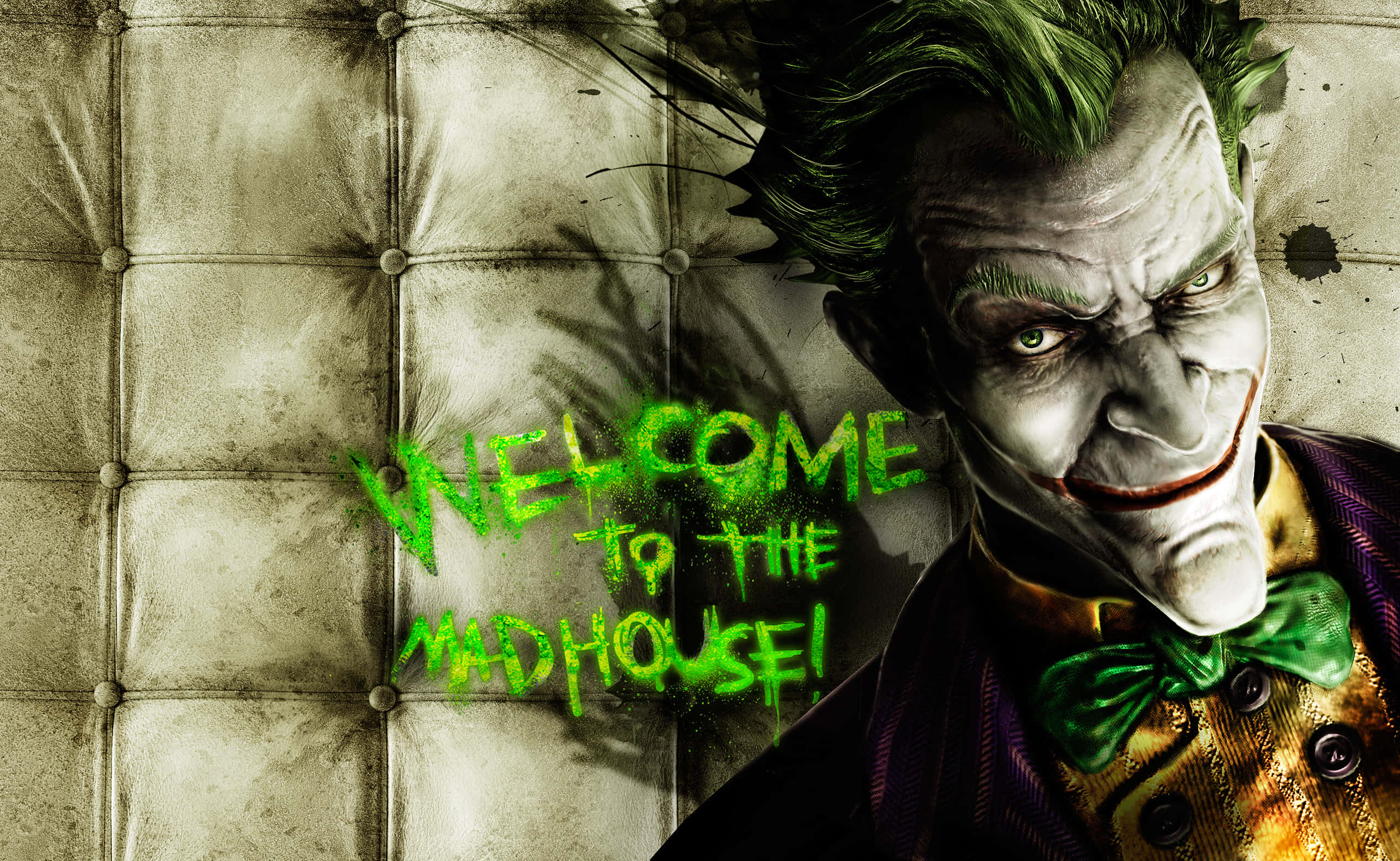 Arkham Asylum 桌布 壁紙 — 小丑威脅性地靠在一張有污漬的簇絨沙發上，上面有綠色塗鴉寫著 'WELCOME TO THE MADHOUSE!'