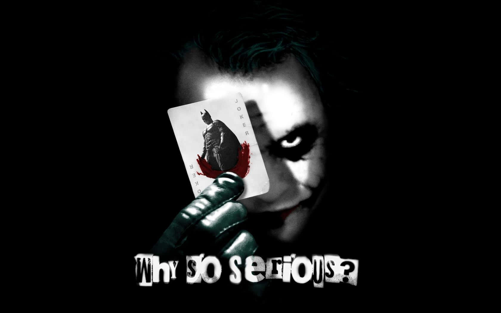 小丑 桌布 壁紙 — 小丑手持沾血的小丑牌，牌上寫著「Why so serious?」，背景是黑色，近距離特寫充滿威脅感。