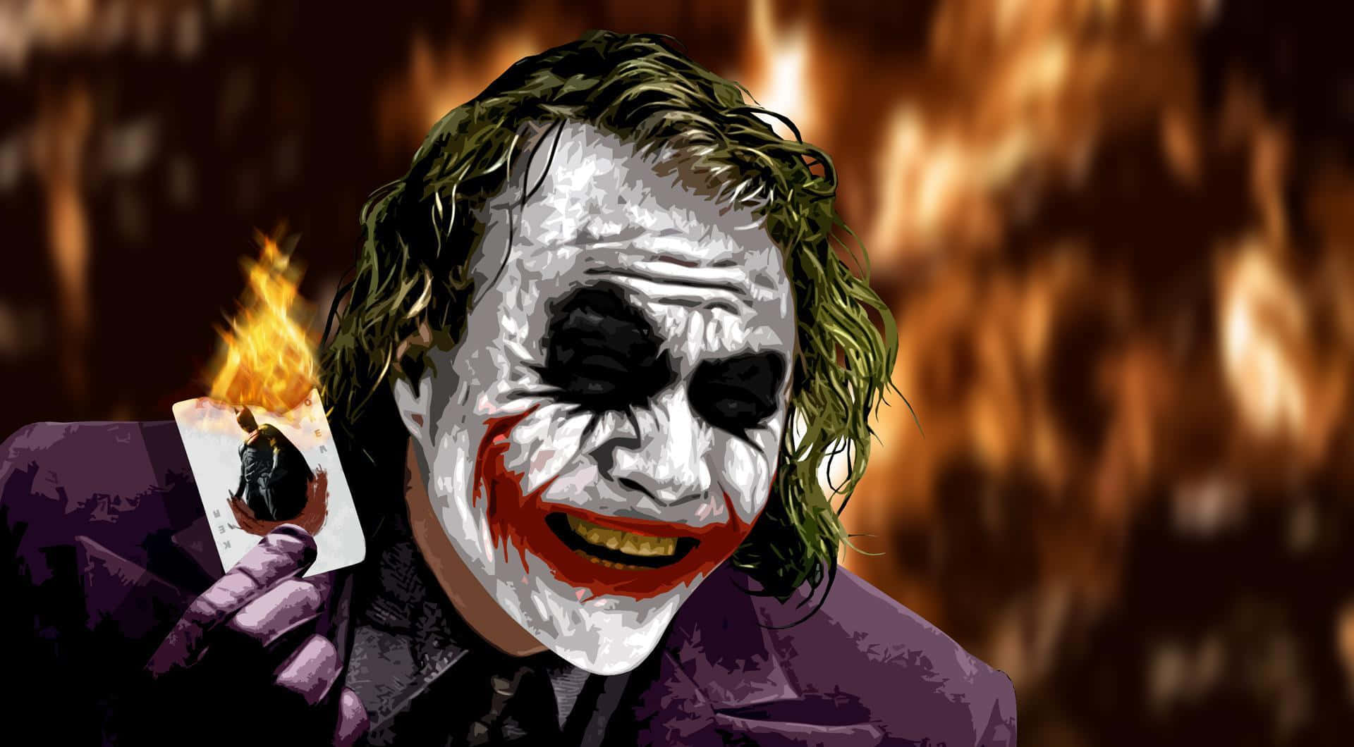 Joker Laughing 桌布 壁紙 — 小丑手持燃燒的撲克牌，背景是火焰，露出邪惡的笑容。