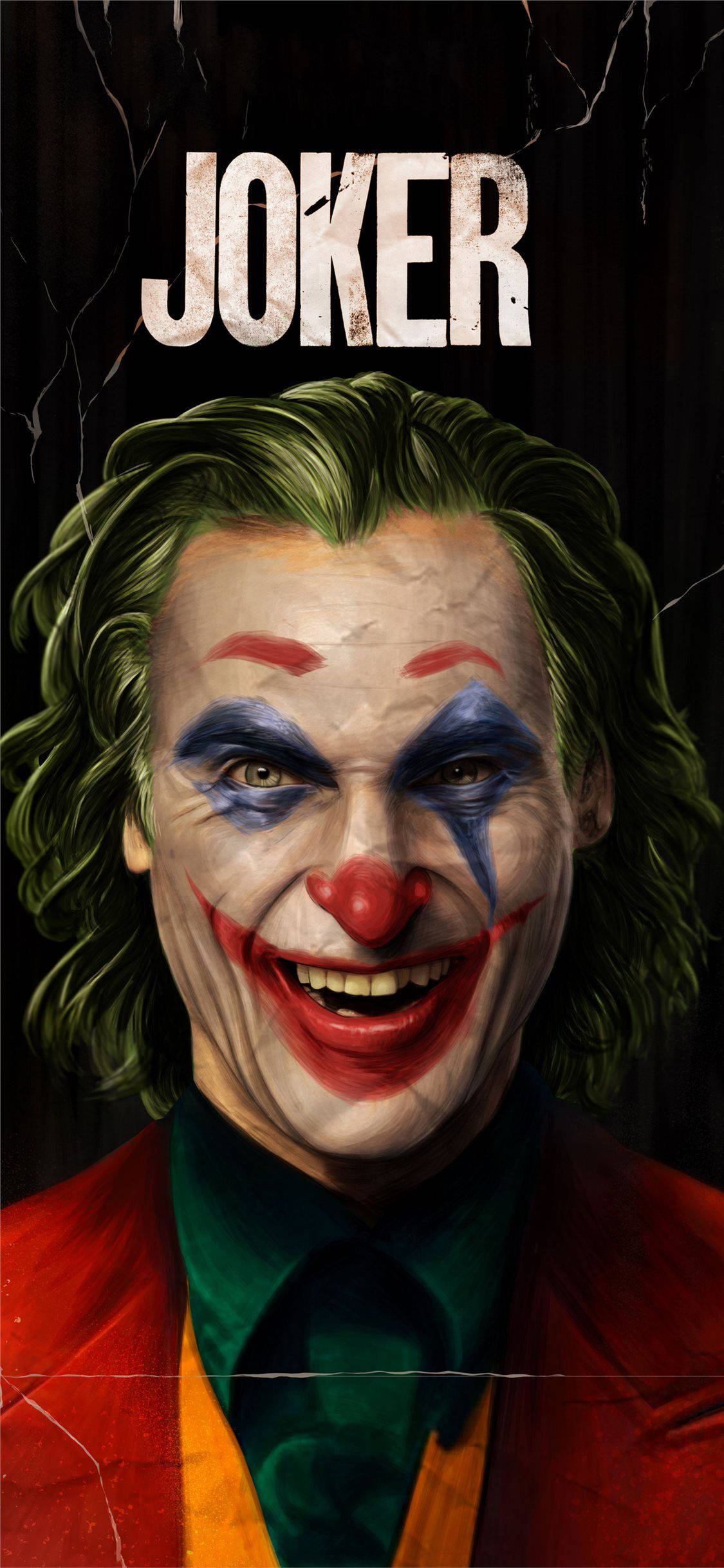 Joker 2019 桌布 壁紙 — 小丑的 close-up 肖像，綠色頭髮、紅色嘴唇、藍色眼妝，在裂開的黑暗背景上露出邪惡的笑容。
