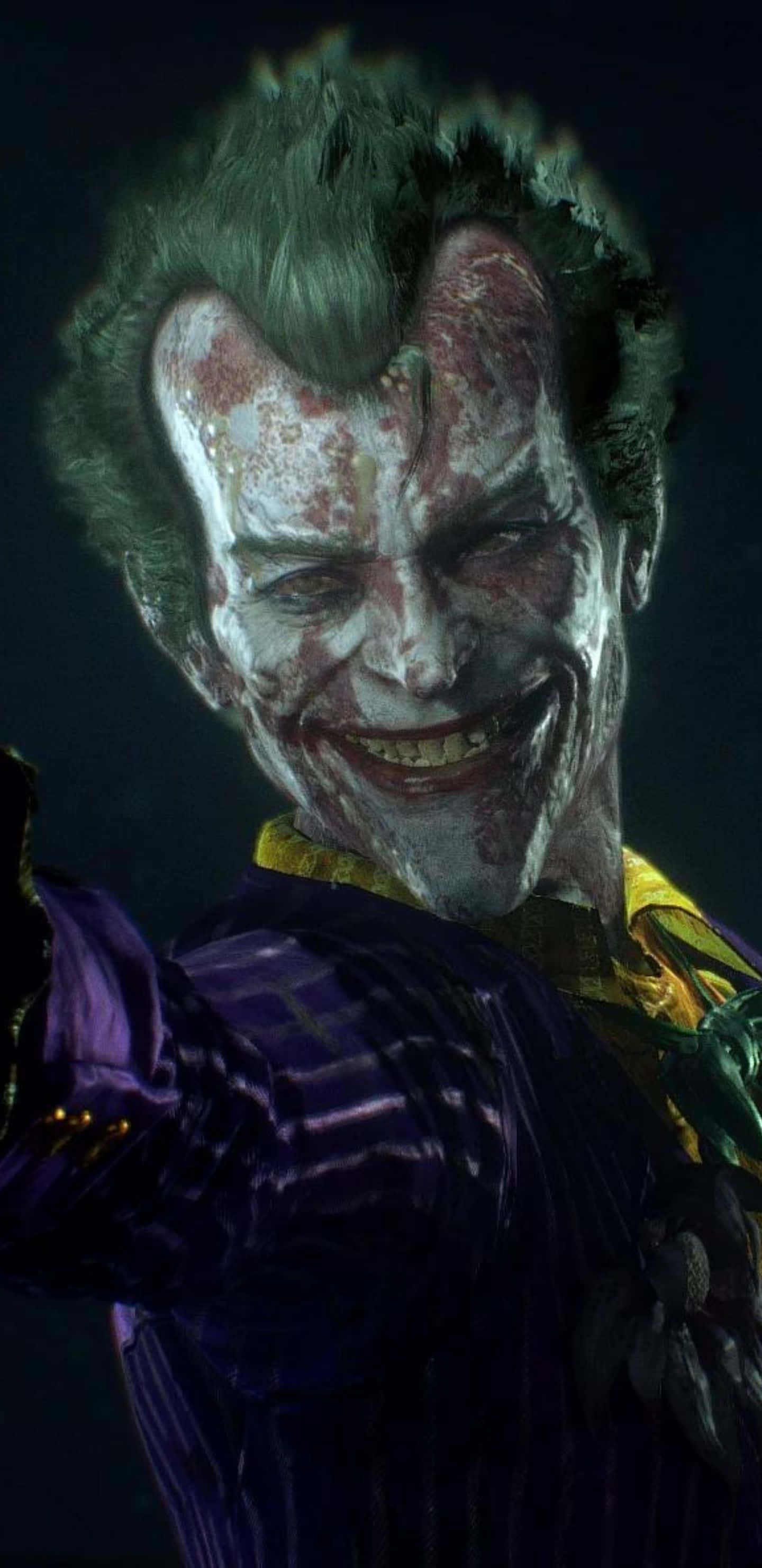 Pixel 3xl Batman Arkham City 桌布 壁紙 — 小丑的近距離威脅特寫，臉上塗抹著白色顏料，在黑暗背景下露出邪惡的咧嘴笑。