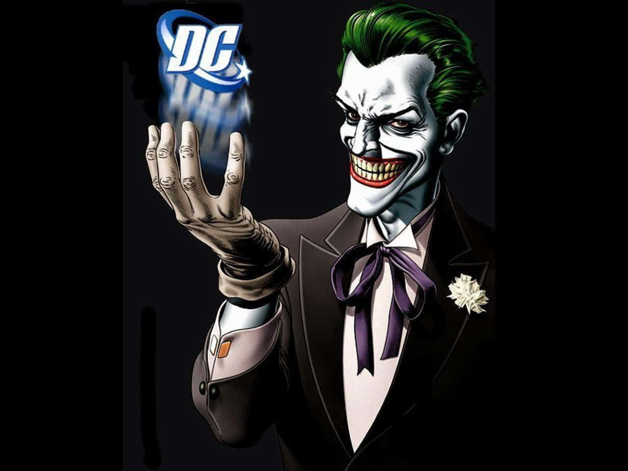 Villain 桌布 壁紙 — 小丑身穿燕尾服，綠色頭髮，紫色領結，戴著手套的手在黑暗背景中握著發光的DC標誌。