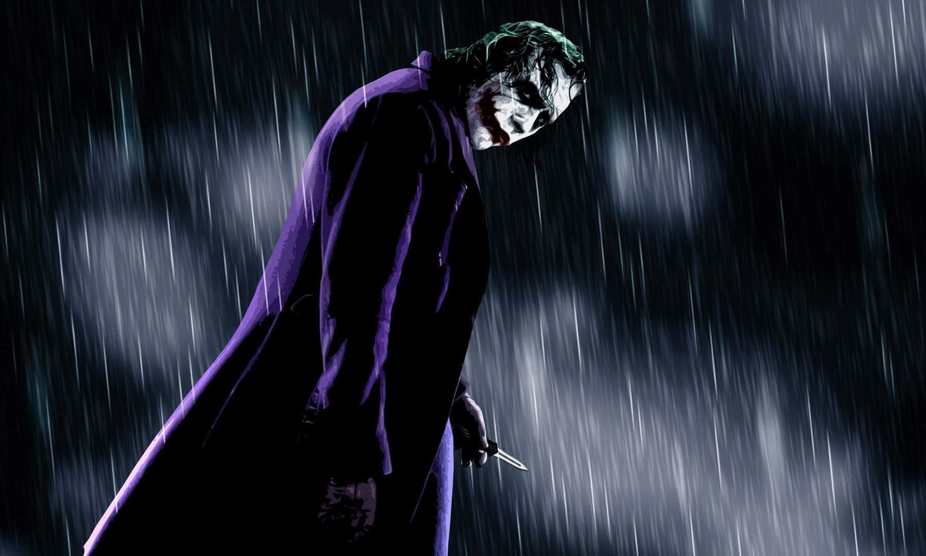 Evil Joker 桌布 壁紙 — 小丑身穿紫色外套，在傾盆大雨中站在戲劇性的燈光下，手持一把刀。