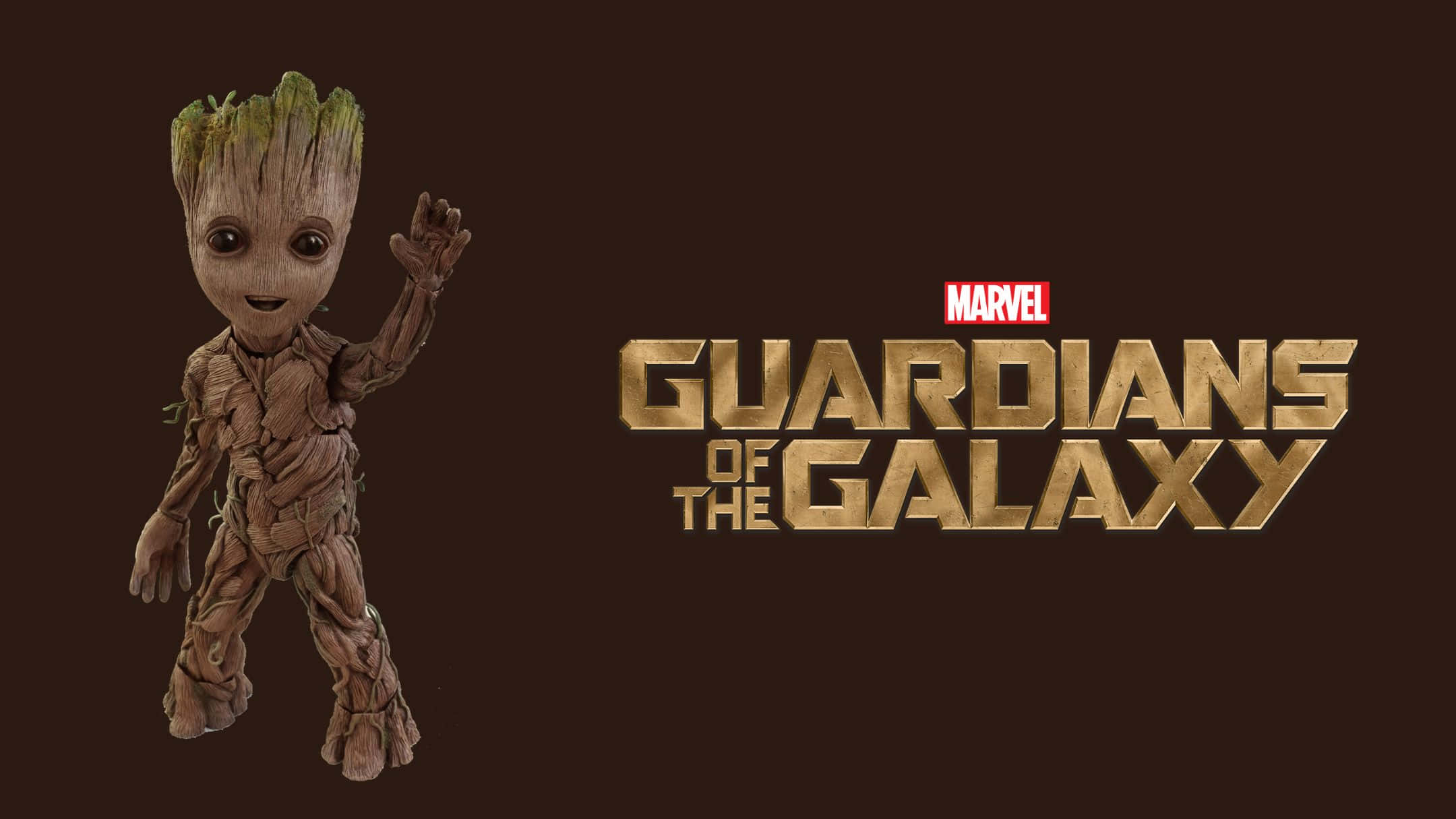Best Marvel 桌布 壁紙 — 小樹人在深棕色背景上，在星際異攻隊標誌旁邊開心地揮手。