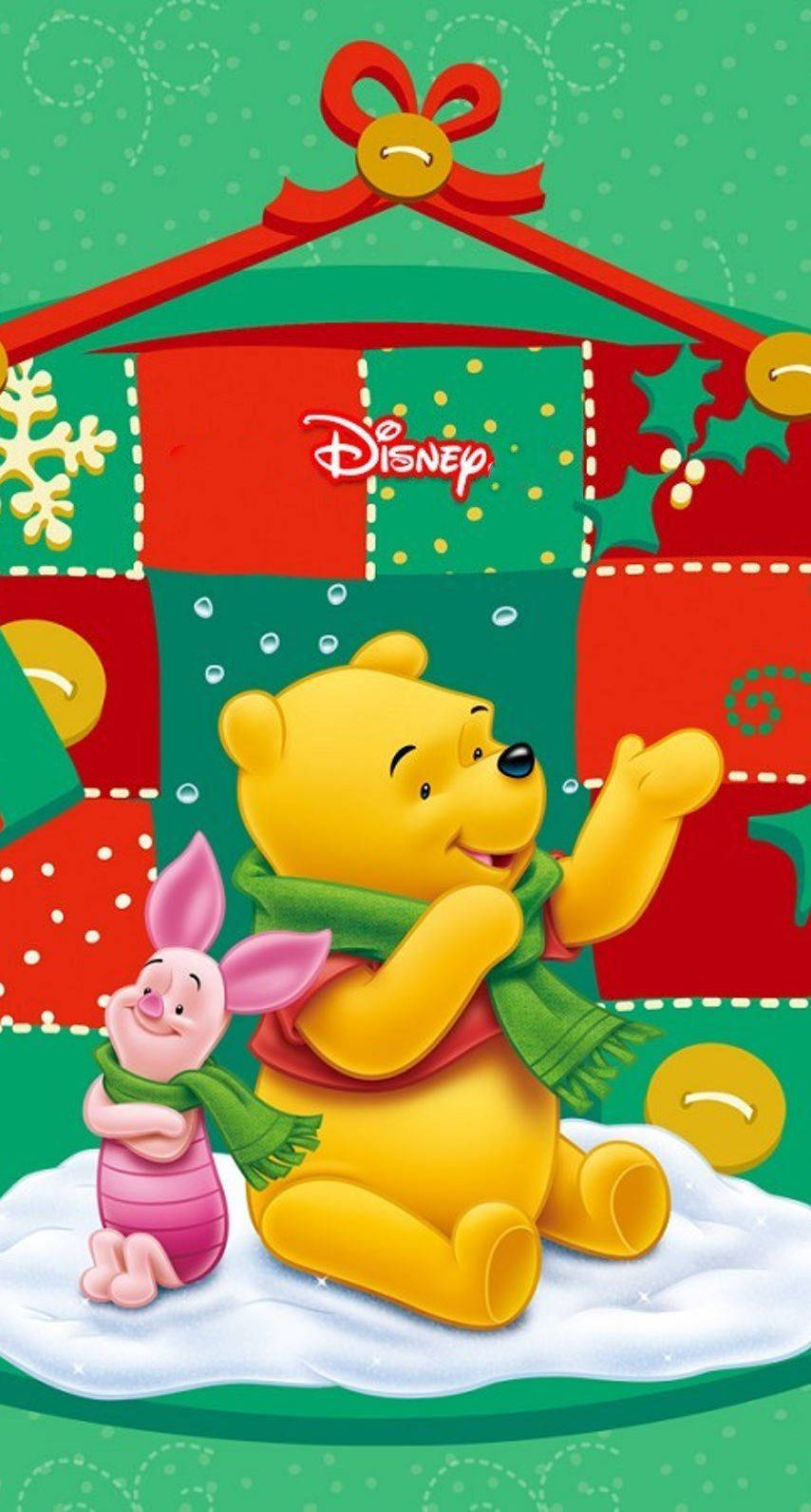 Winnie The Pooh Christmas 桌布 壁紙 — 小熊維尼和小豬戴著節日圍巾坐在雪地上，上方是色彩繽紛的拼布聖誕屋頂，帶有迪士尼標誌。