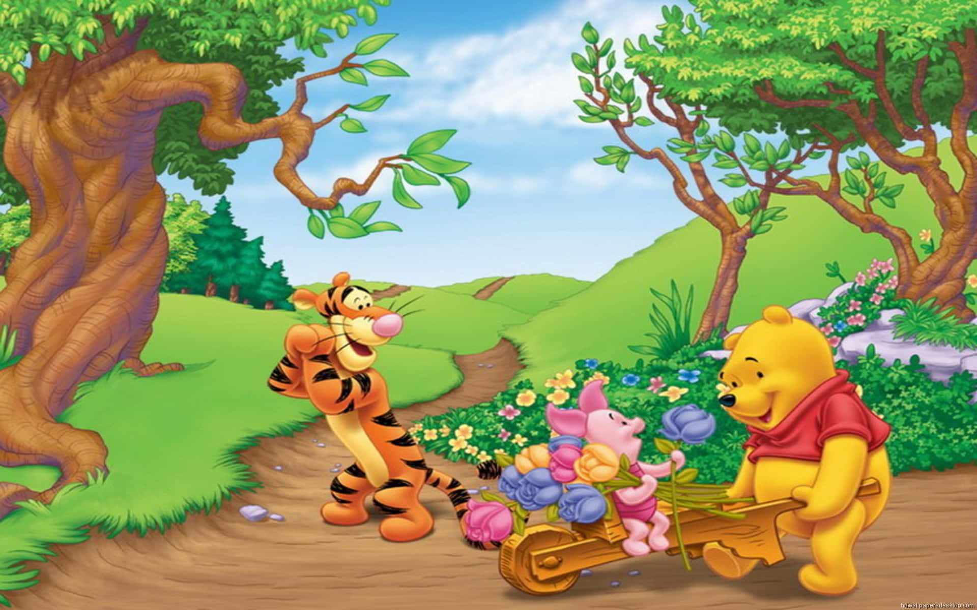 winnie the pooh 桌布 壁紙 — 小熊維尼和小豬推著一輛裝滿彩色花朵的手推車，沿著蜿蜒的林間小路前進，跳跳虎高興地看著。