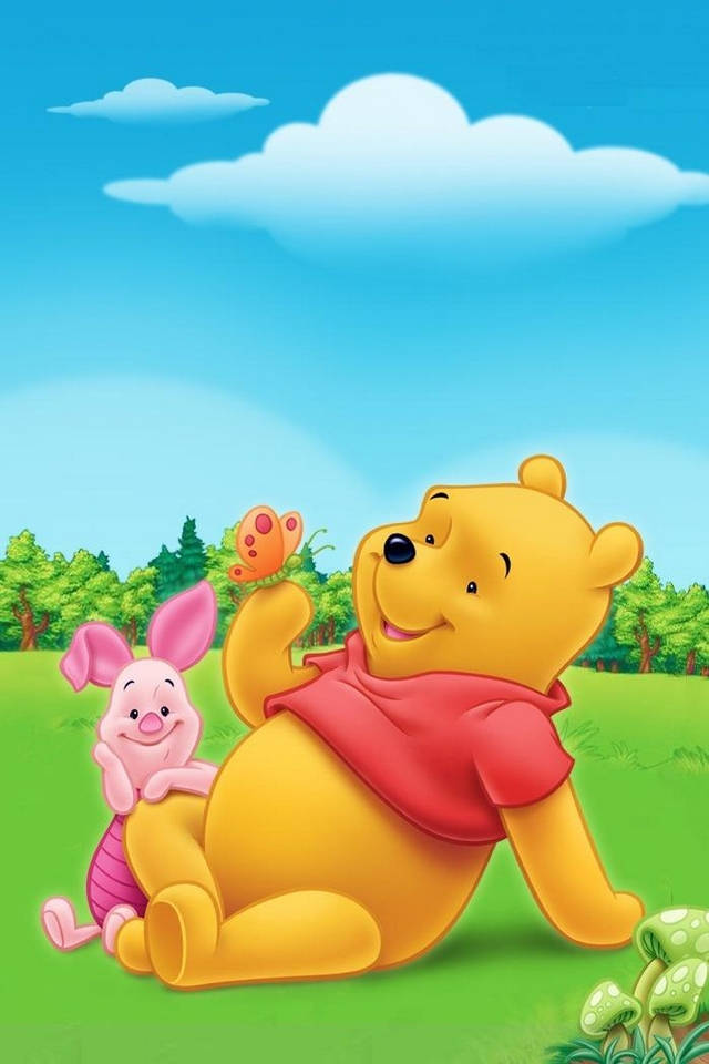 winnie the pooh 桌布 壁紙 — 小熊維尼和小豬皮傑開心地坐在陽光明媚的草地上，天空藍藍的，有蓬鬆的白雲。