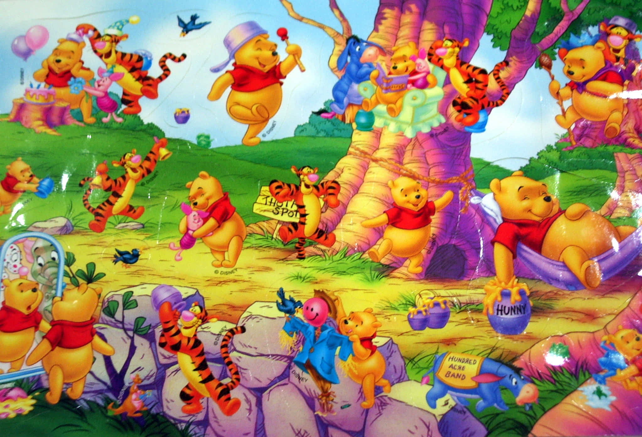 winnie the pooh 桌布 壁紙 — 小熊維尼和朋友們在充滿活力的卡通森林場景中，圍著一棵巨大的樹歡樂地慶祝。