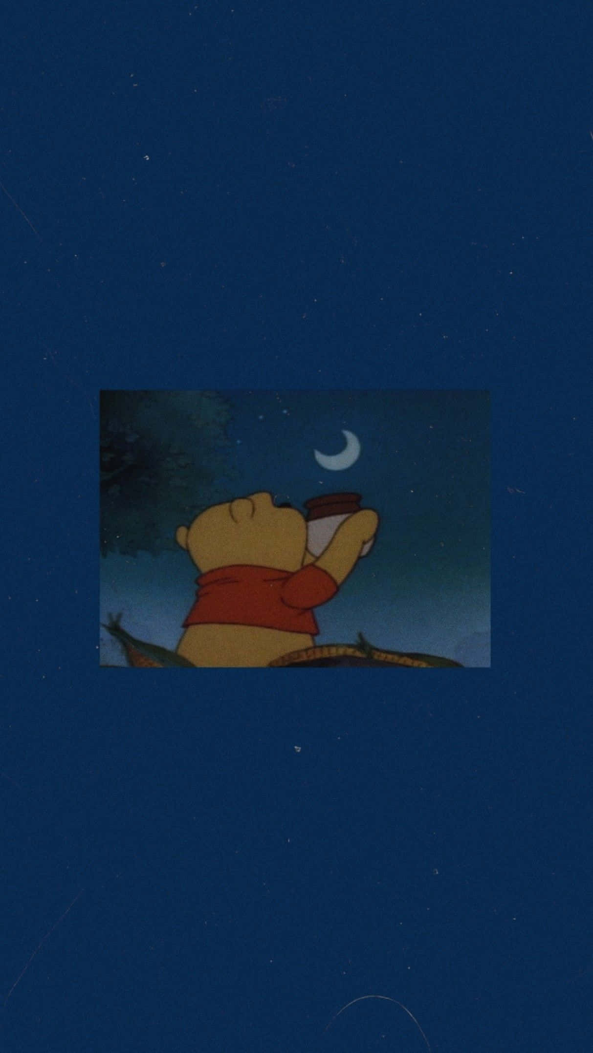 Dark Aesthetic Cartoon 桌布 壁紙 — 小熊維尼在深藍色夜空下，手持杯子仰望新月和星星。