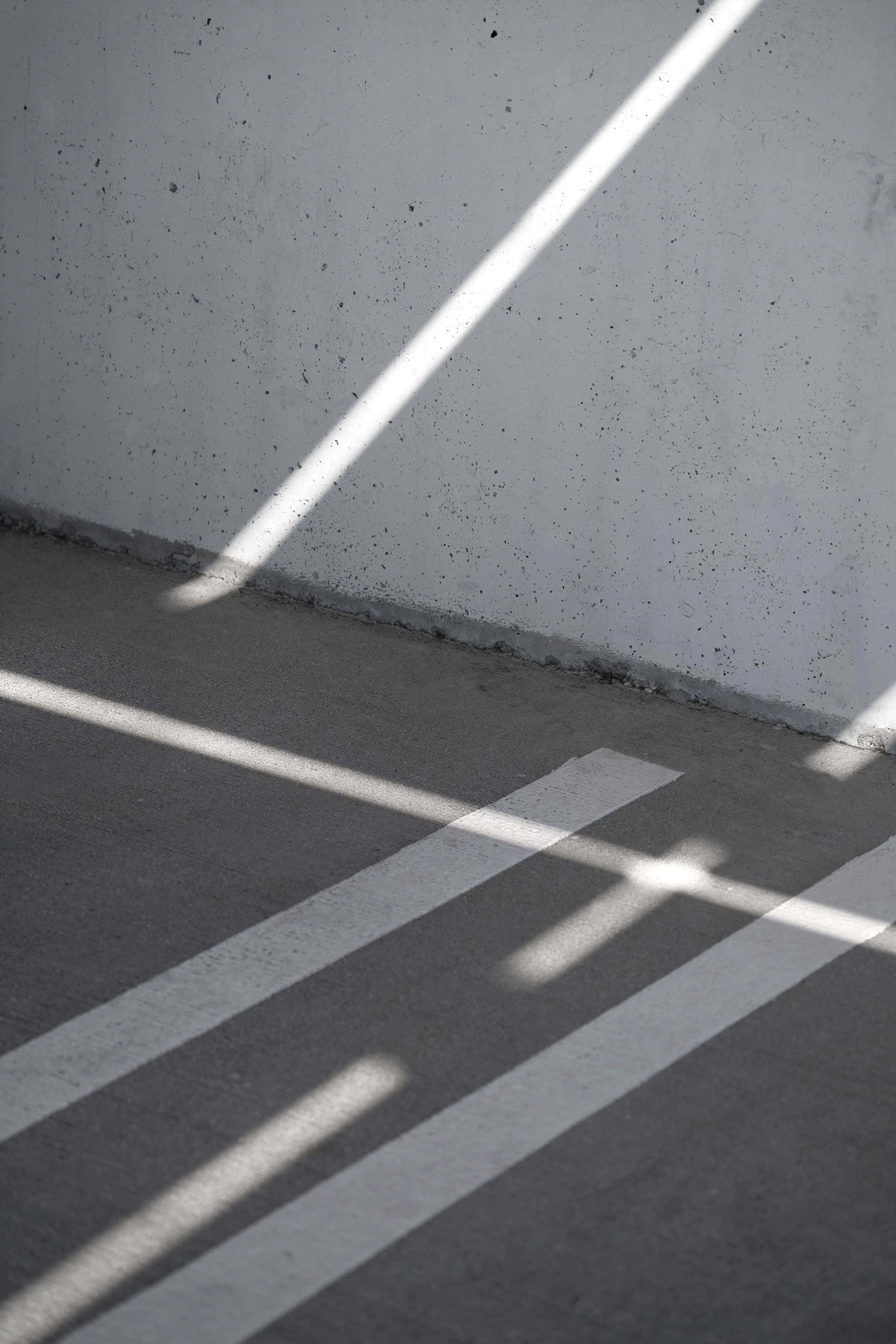 Minimalist Photography 桌布 壁紙 — 尖銳的對角陽光光束穿過混凝土地板和牆壁，投射出鮮明的幾何陰影。