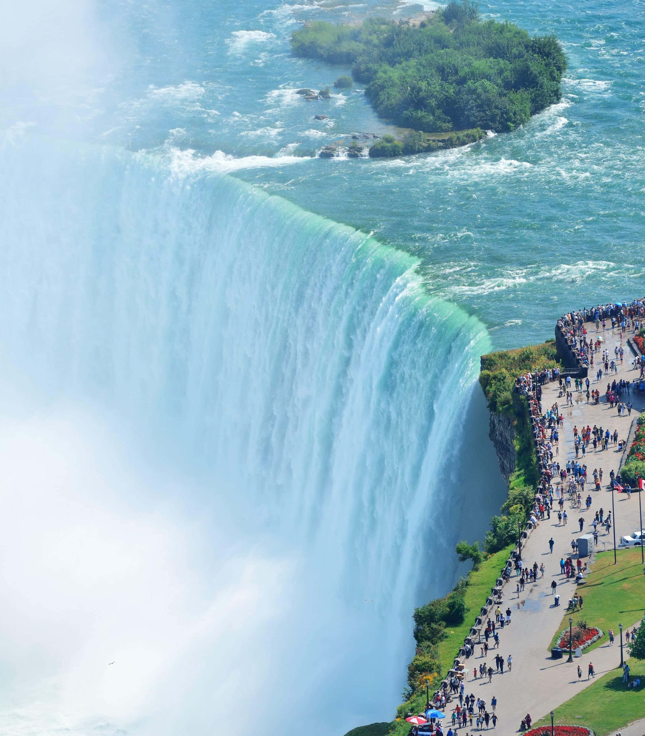 Niagara Falls 桌布 壁紙 — 尼亞加拉大瀑布的鳥瞰圖，瀑布強勁傾瀉，水霧升騰，下方觀景步道上人群聚集。