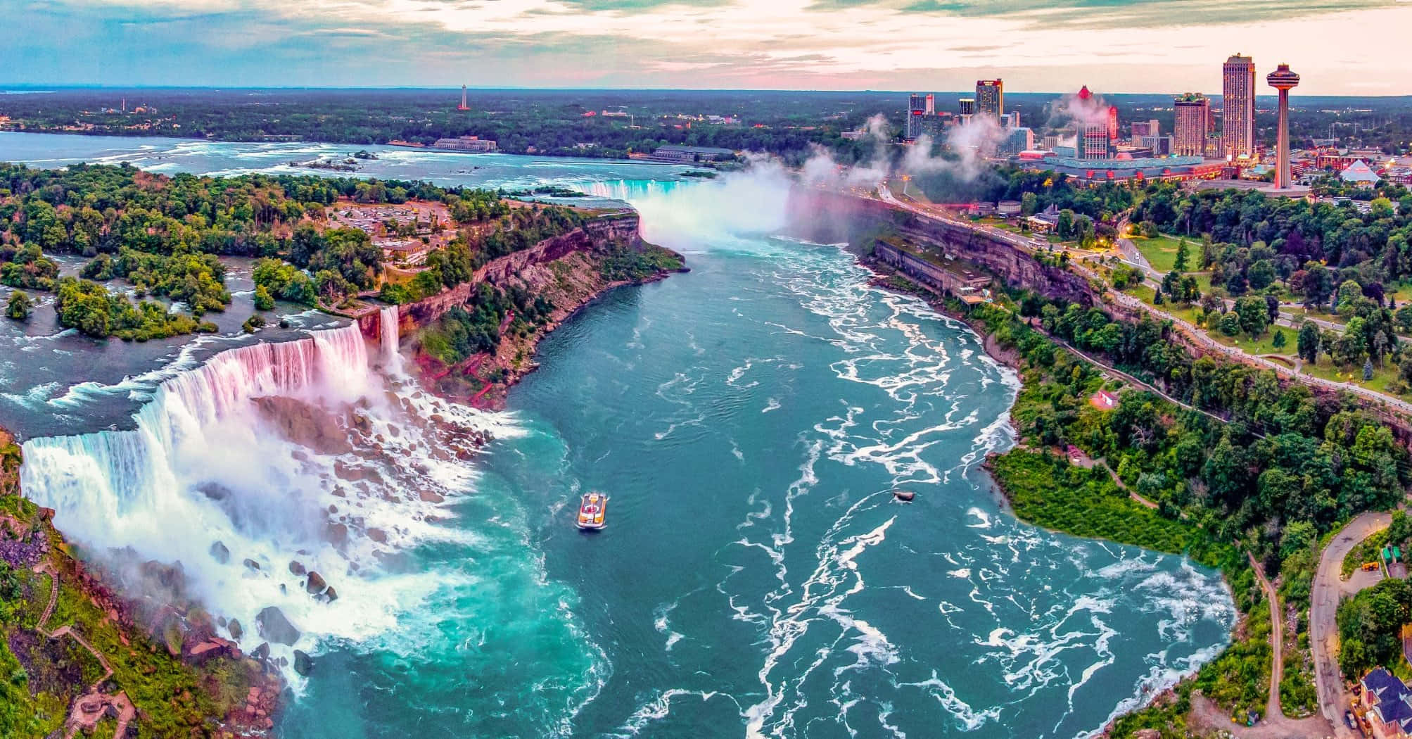 Niagara Falls 桌布 壁紙 — 尼亞加拉大瀑布的鳥瞰圖，瀑布水流激起霧氣，右側可見城市天際線。