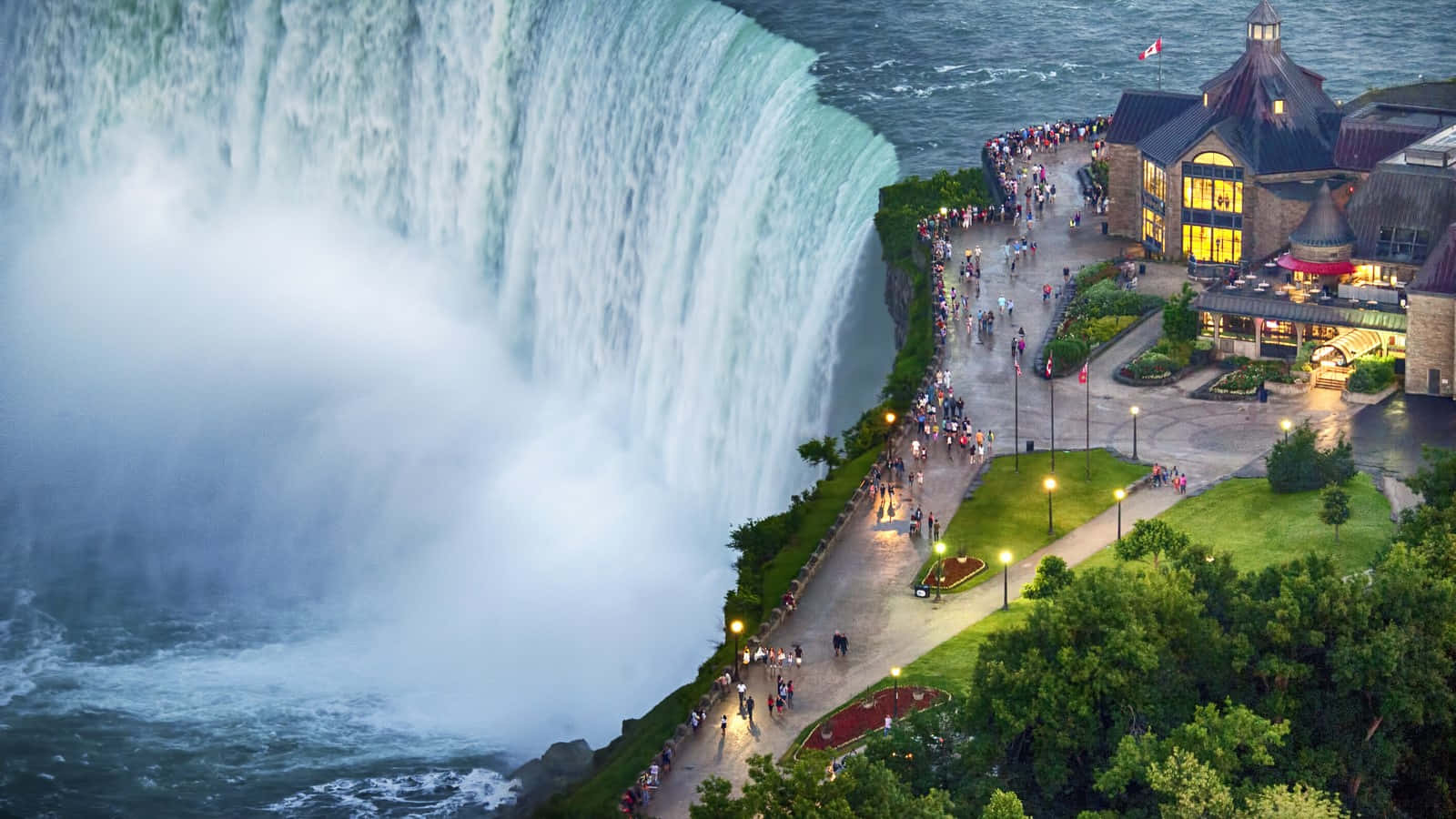 Waterfalls 桌布 壁紙 — 尼亞加拉大瀑布黃昏時的鳥瞰圖，有照明的小徑和石建築附近的群眾。