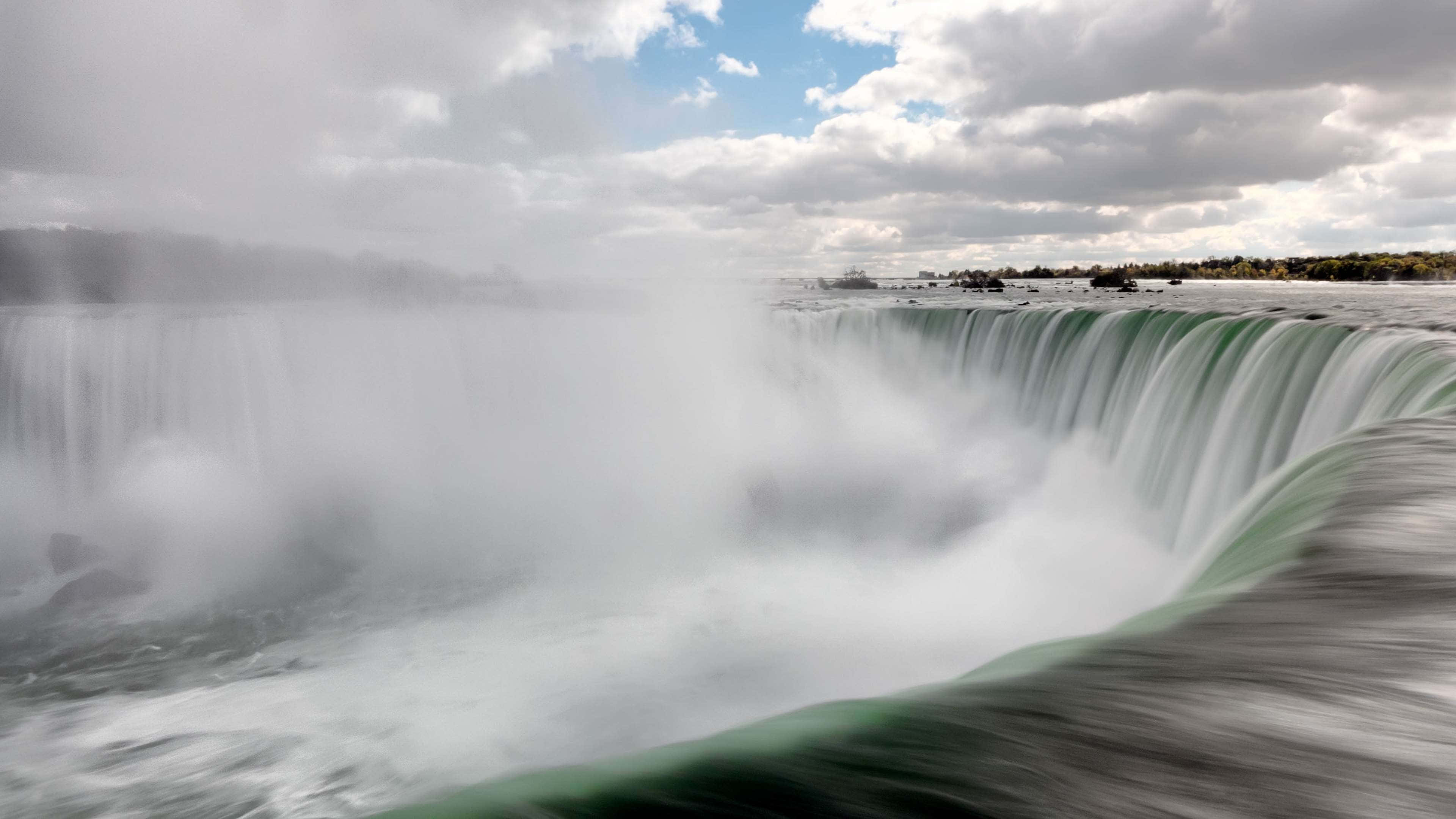 720p Niagara Falls 桌布 壁紙 — 尼加拉瀑布在陰天天空下帶著薄霧傾瀉而下的強力廣角鏡頭。