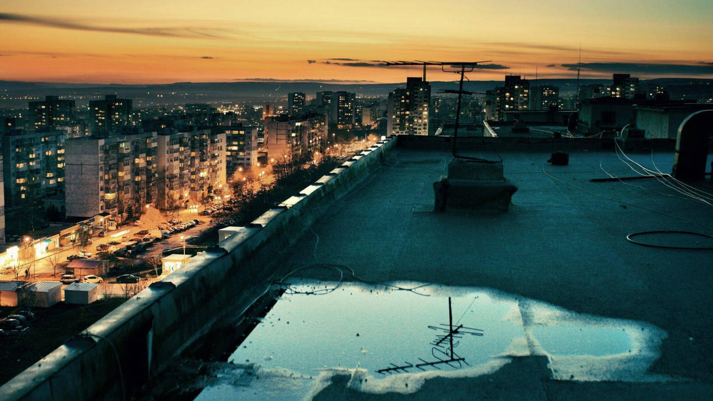 Rooftop 桌布 壁紙 — 屋頂泳池倒映著夕陽，城市景觀中窗戶和街燈閃爍著光芒。