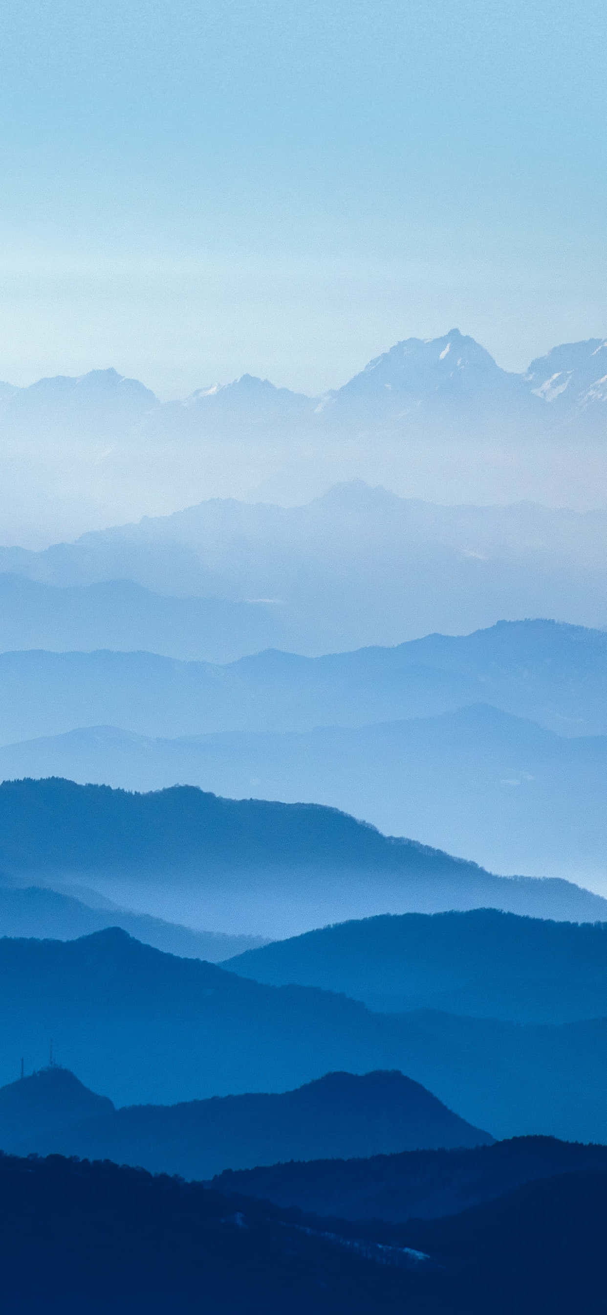 山景 桌布 壁紙 — 層層疊疊的山脈在晴朗的天空下逐漸融入大氣藍色的薄霧中。