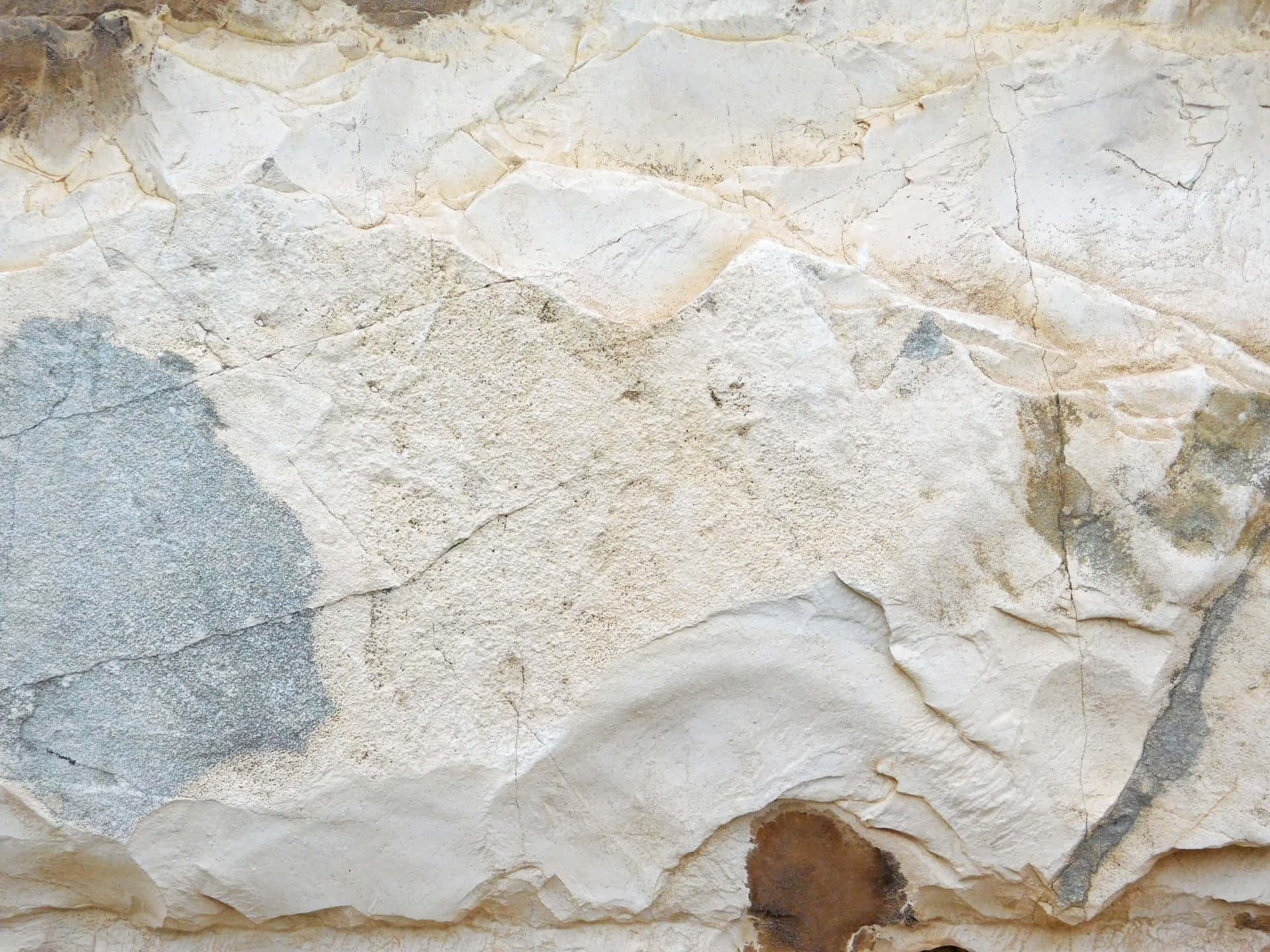 Stone texture 壁紙 — 層狀沉積岩的特寫，呈現米色、白色、灰色和棕色色調，顯示自然裂縫和侵蝕圖案。