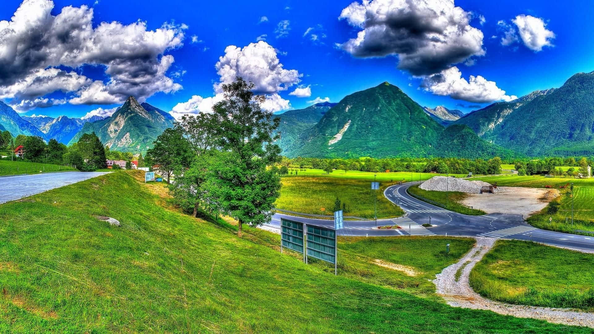 山間道路與翠綠田野的景致 壁紙