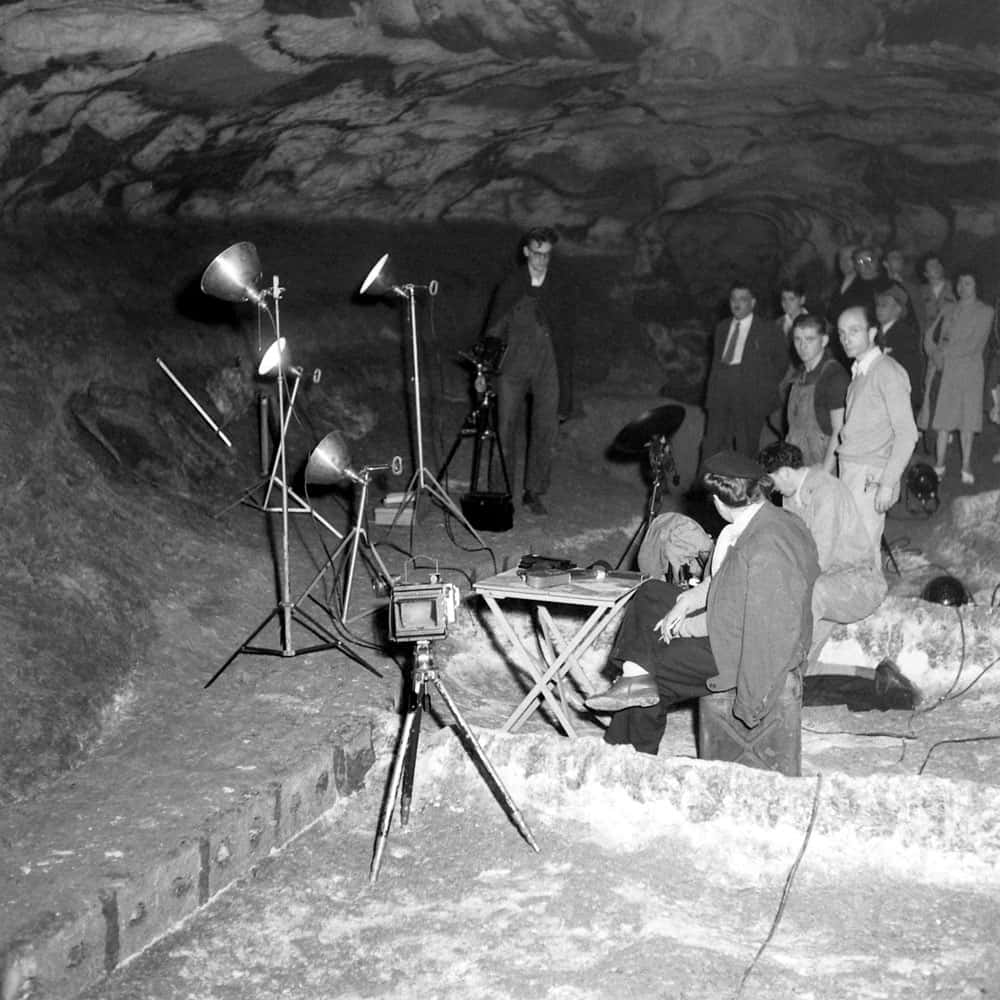 Lascaux Caves 桌布 壁紙 — 岩洞內電影攝製組帶著相機和燈光，有旁觀者的復古黑白照片。