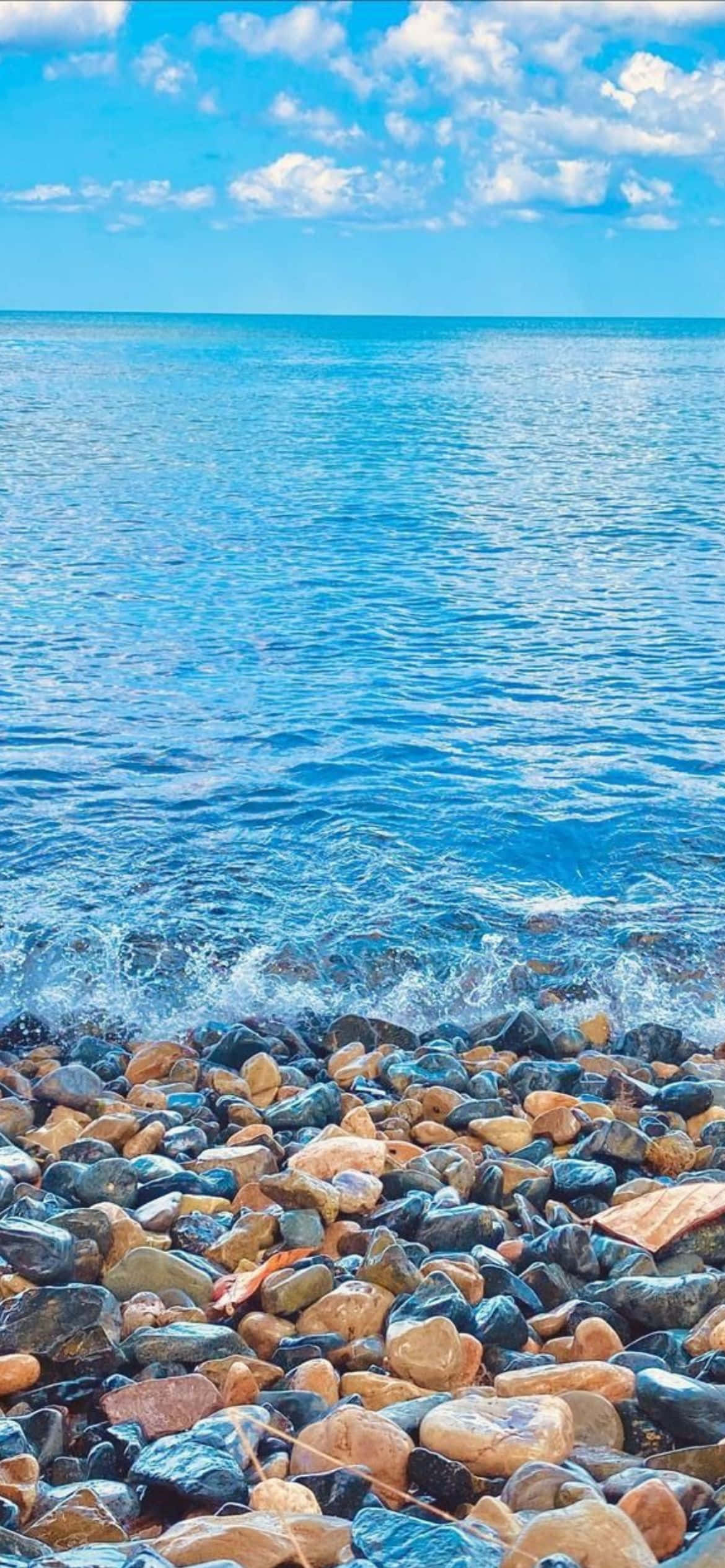 岩石與海水交織的海灘 壁紙