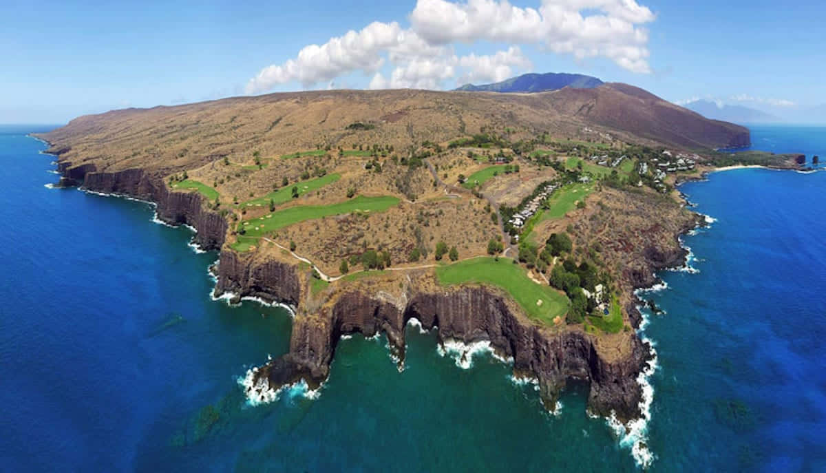 Hawaiian Island 桌布 壁紙 — 崎嶇海岸島嶼的鳥瞰圖，鬱鬱蔥蔥的高爾夫球場坐落在壯麗的懸崖和碧綠的海水之間。