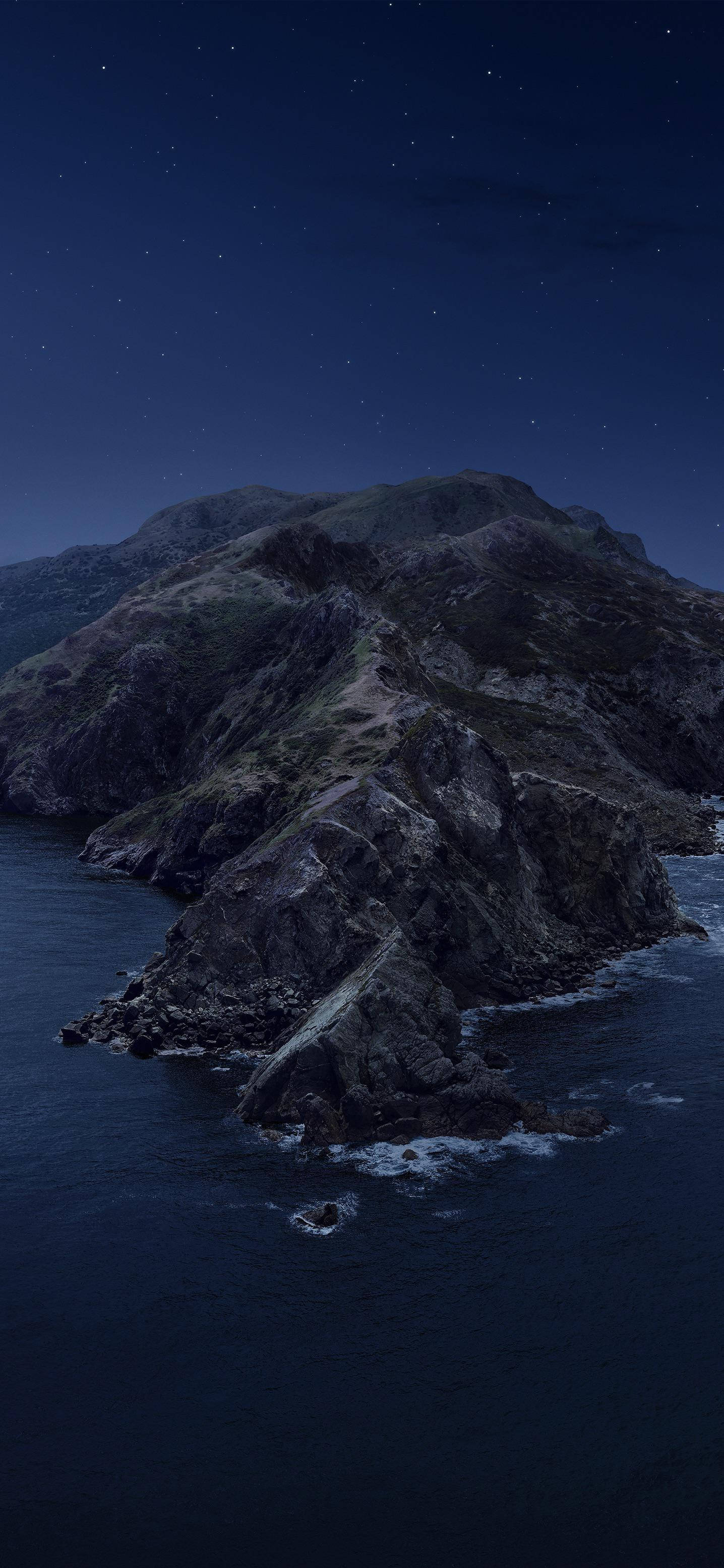 山景 桌布 壁紙 — 崎嶇的山崖在繁星點點的夜空下伸入黑暗的海洋，溫柔的波浪在下方拍打。